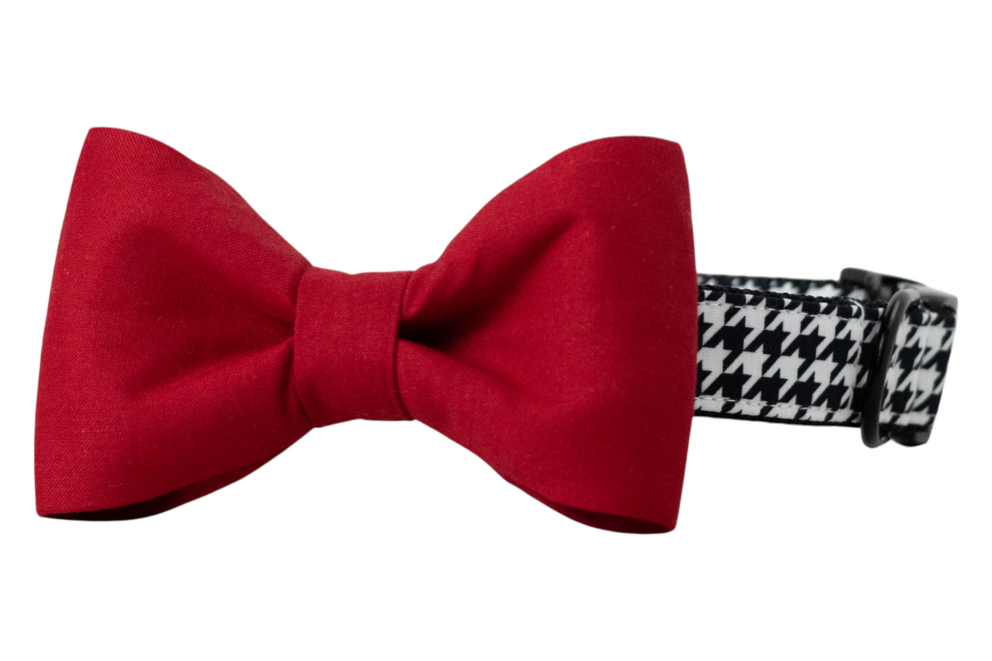 A black and white houndstooth-patterned dog collar with a bold, attached red bow tie. The collar features a classic, adjustable design with black hardware, while the classic bow tie adds a striking, formal touch—ideal for holiday, game day, or special occasion wear.