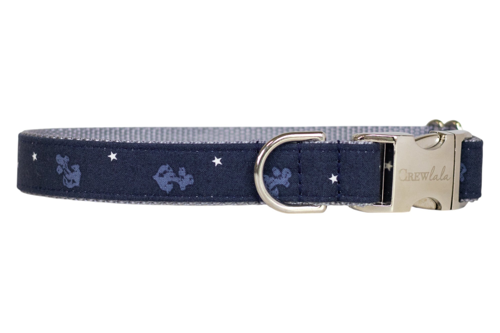 Nautical-themed navy blue dog collar featuring light blue anchor designs and white stars, finished with a polished metal D-ring and buckle.