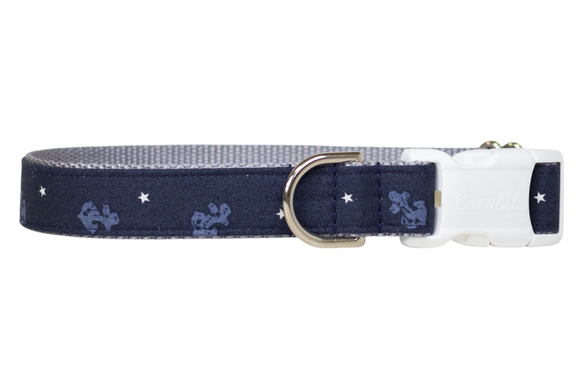 Nautical-themed navy blue dog collar featuring light blue anchor designs and white stars, finished with a polished metal D-ring and and white buckle.