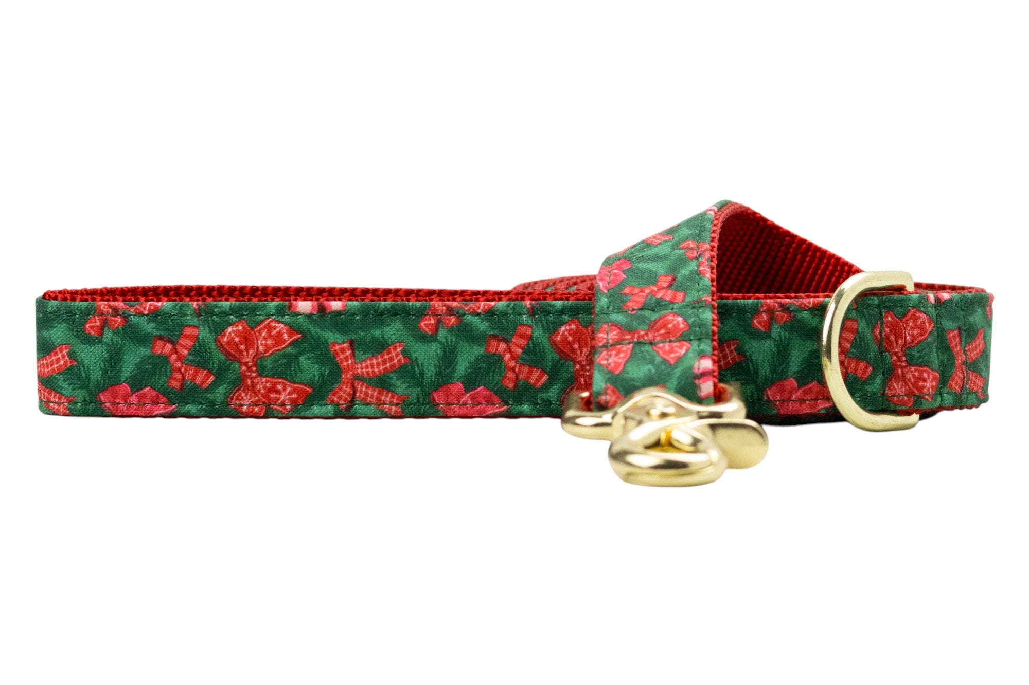 A festive dog leash made from green fabric decorated with bows in various patterns, set against a pine-like background. The leash features a nylon webbing lining for durability and metal hardware.