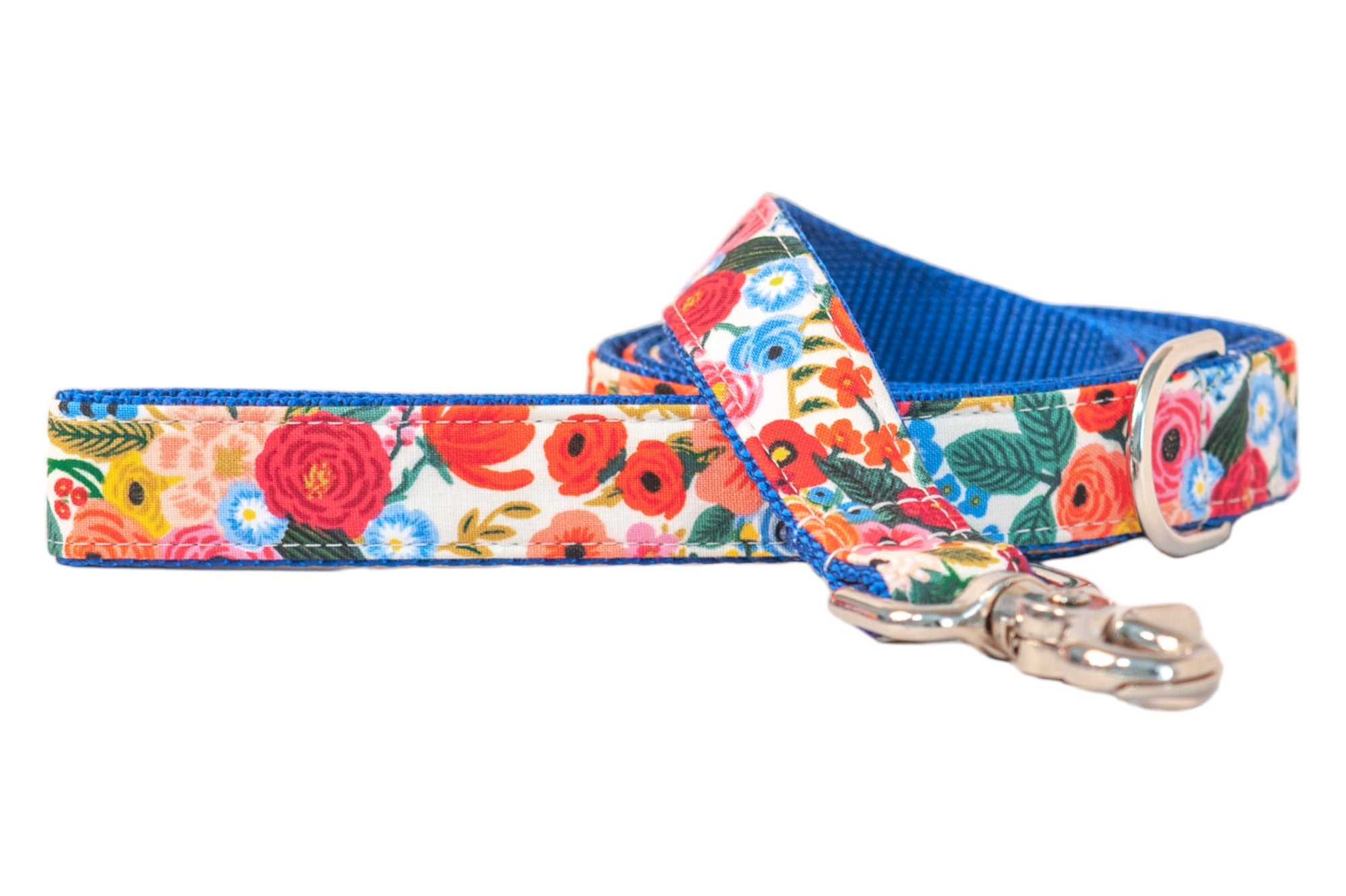 A colorful dog leash with a bright floral pattern, including various blooms and green leaves. The leash is accented with blue webbing on the interior and edges, and finished with a silver clasp for collar attachment.