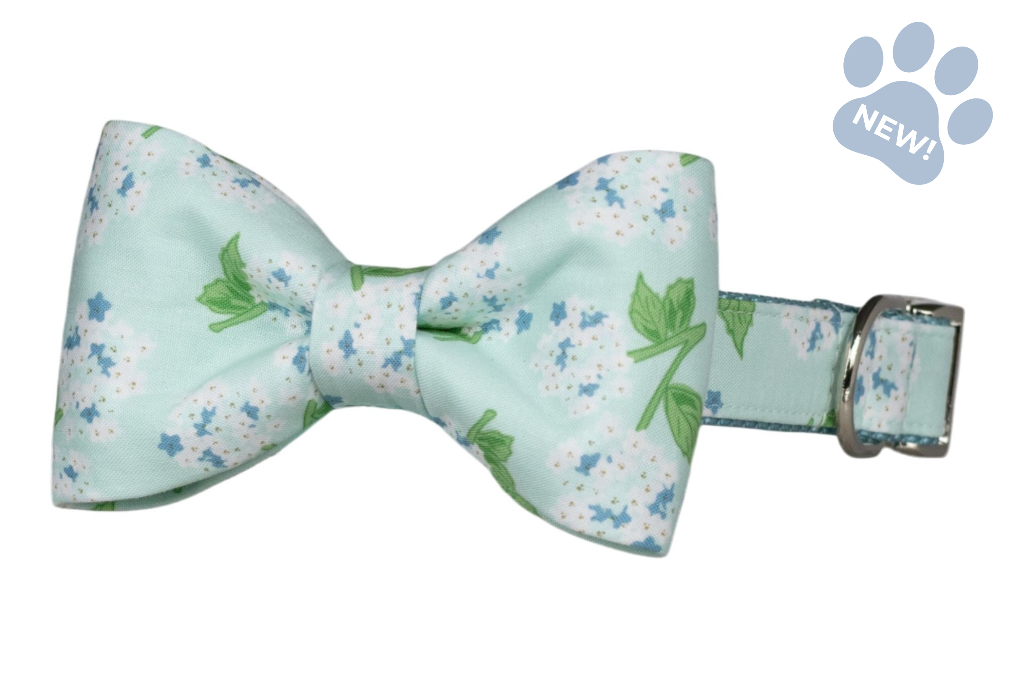 Hydrangea-print bow tie dog collar featuring a classic bow tie with white hydrangea blooms, blue floral accents, and green leaves on a soft mint blue background, attached to a matching collar with silver-tone hardware.