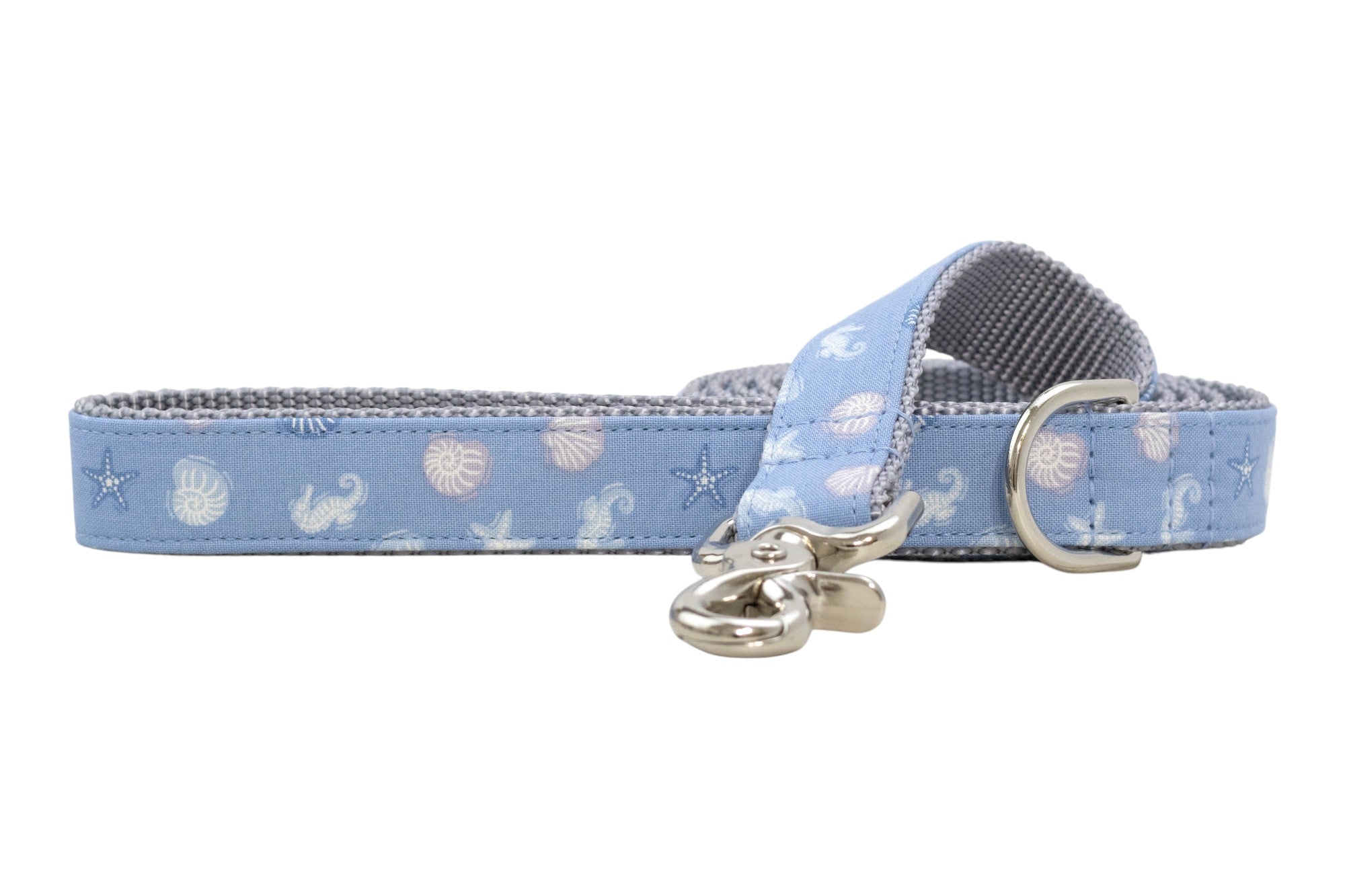 Light blue dog leash with white seashell and starfish pattern, featuring a silver clasp and D-ring, shown on a white background.