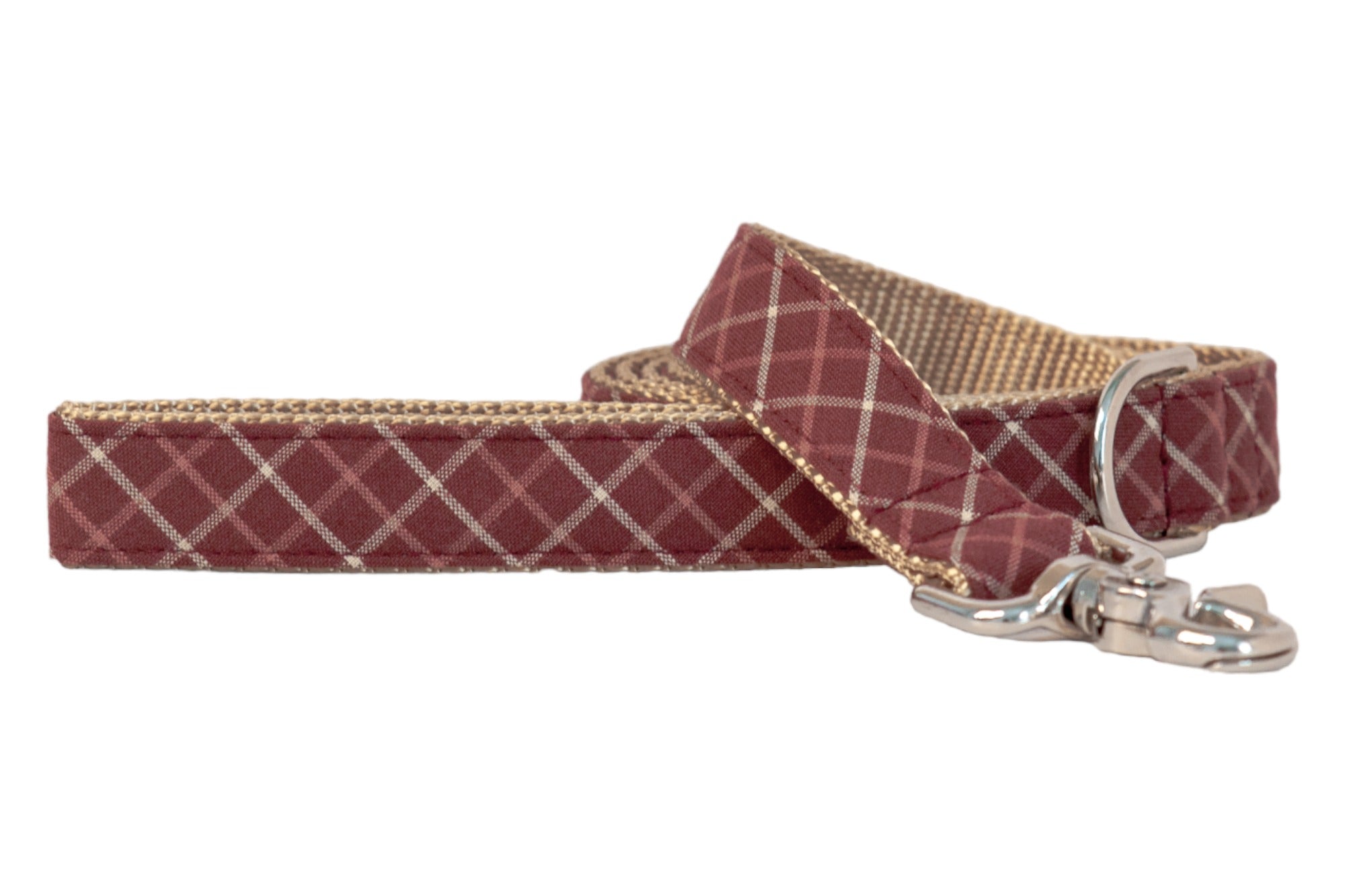 Stylish dog leash made from burgundy fabric with a subtle plaid pattern. It’s lined with nylon webbing and features metal hardware, including a D-ring and a clasp for attachment.