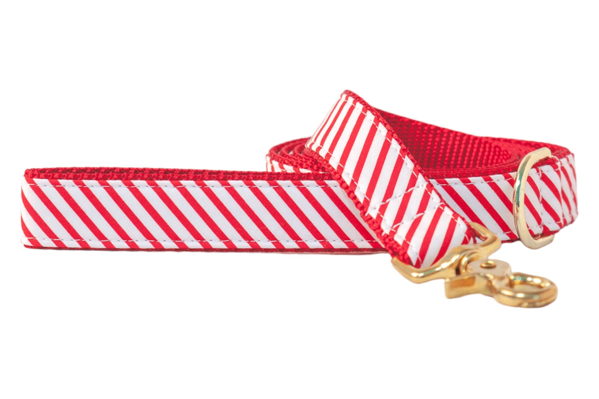 Holiday dog leash with diagonal candy cane stripes. Made with durable red backing, reinforced stitching, and shiny hardware for seasonal strolls in style.