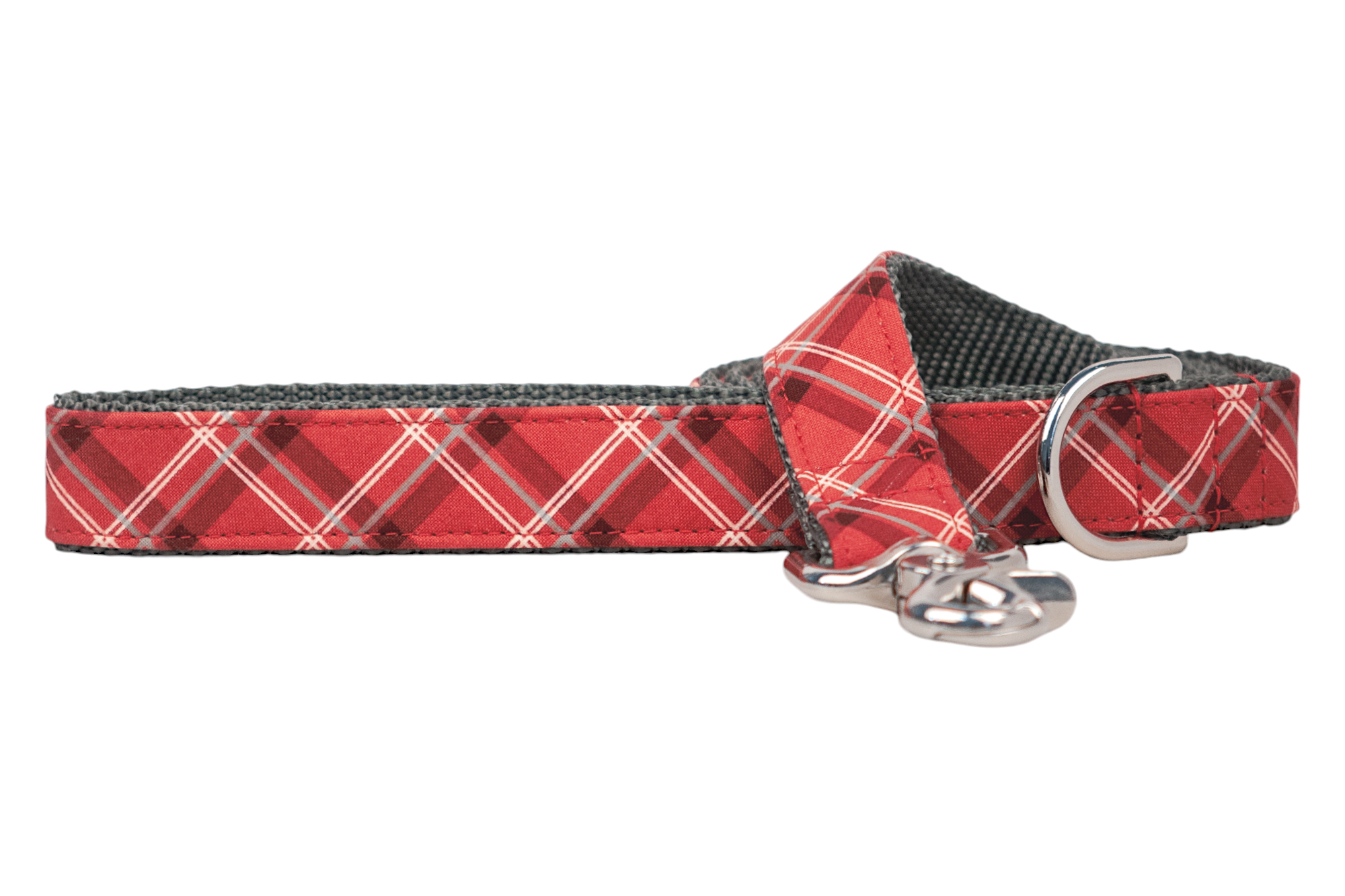 A red plaid dog leash, handmade in Charleston, SC, with a tartan design. The leash features a metal clasp and a matching D-ring near the handle. The inner side is lined with durable webbing for strength and comfort.