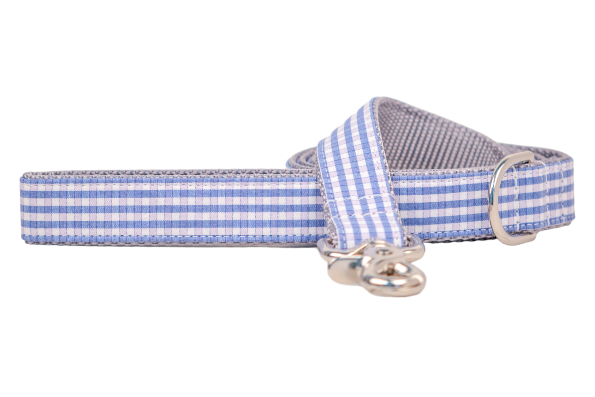 A close-up of a dog leash in a blue, pink, and white checkered gingham design. The leash is rolled with a visible silver swivel clasp and a metal D-ring integrated near the handle loop for added functionality.