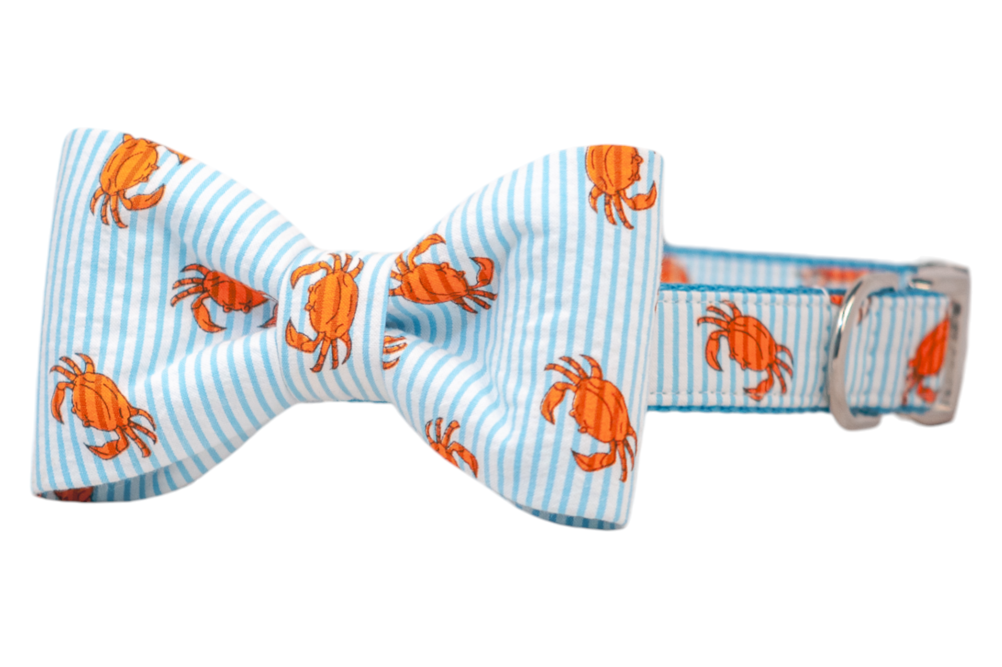 Close-up of a dog collar with a matching symmetrical bow tie in a nautical crab pattern. The fabric showcases playful orange crabs on a crisp blue-and-white striped background. The collar features reinforced stitching and polished silver hardware.