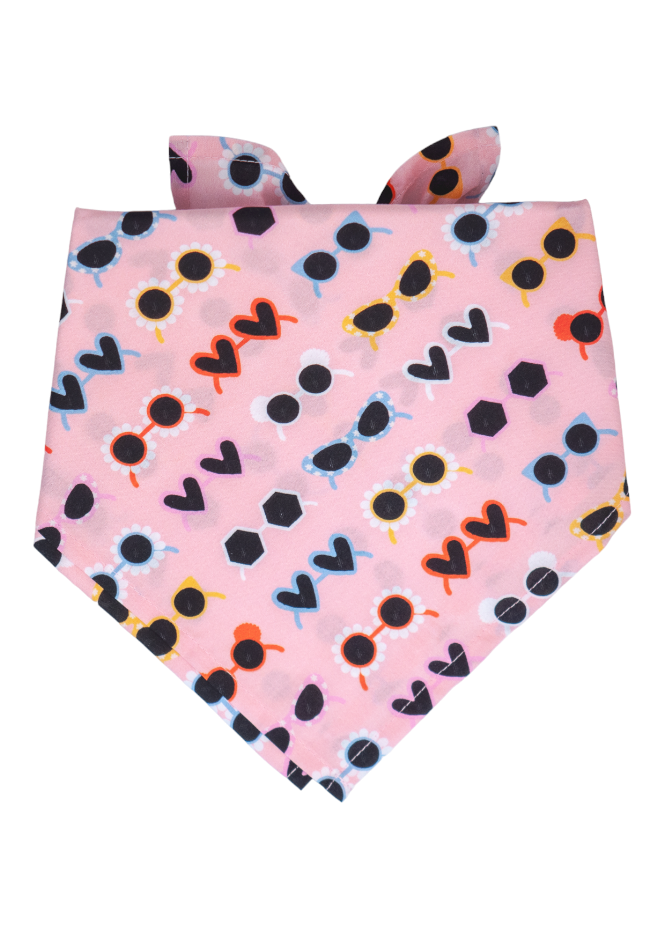 Fun and vibrant dog bandana in soft pink, decorated with a repeating pattern of stylized sunglasses in assorted shapes and colors—red hearts, yellow cat-eyes, black daisies, and geometric frames. The bandana is tied at the back, forming a downward-pointing triangle.