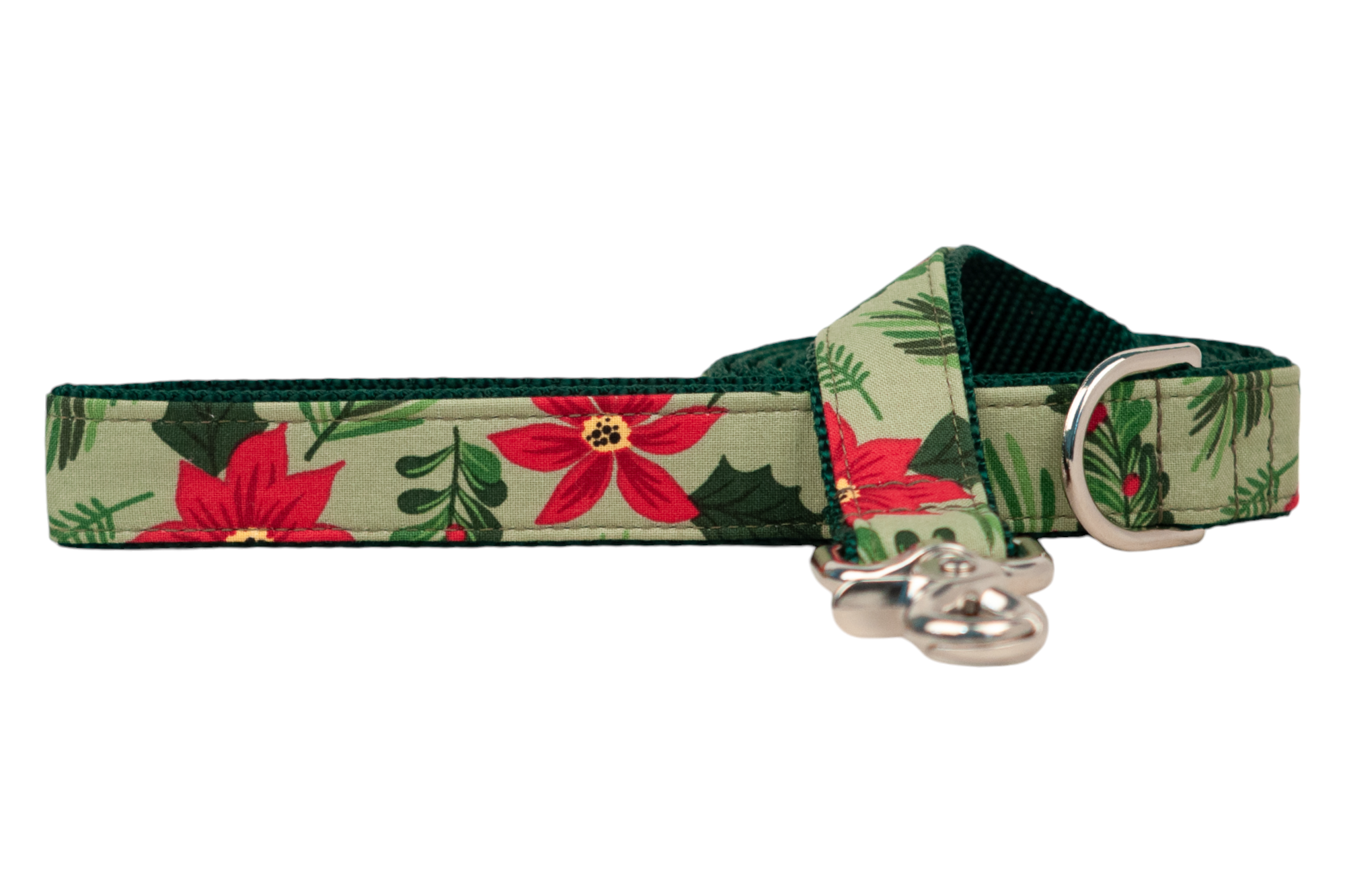 A festive dog leash made of fabric with poinsettias, green pine needles, holly, and mistletoe on a muted green background. The edges are neatly stitched with dark green thread, and the interior is lined with durable green nylon webbing. The leash includes a metal swivel clasp and D-ring.