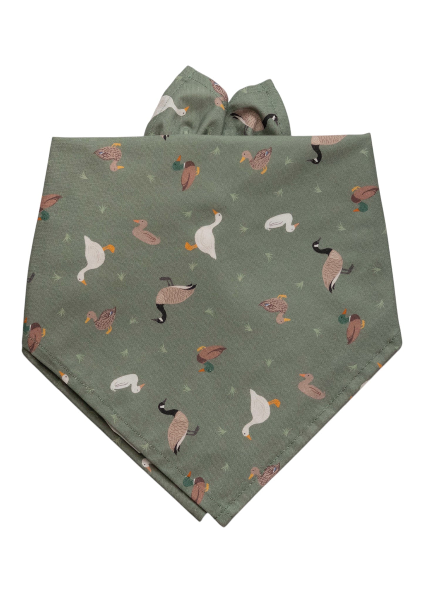 Sage green dog bandana with an all-over print of illustrated ducks, geese, and mallards, scattered with small green grass tuft accents.