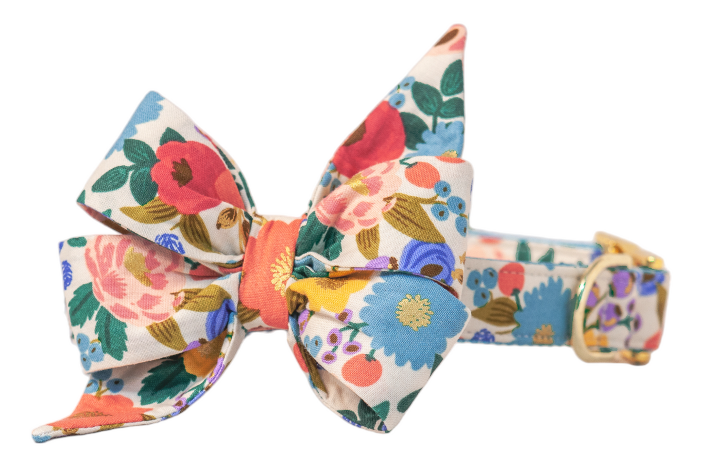 Floral dog collar and belle bow set crafted from a soft cream base with an intricate garden print of bold, multicolored flowers and berries. The oversized belle bow, shaped with two upward flared points and two downward tails, adds a whimsical and feminine flair. A shiny buckle and loop accent the collar’s structure.