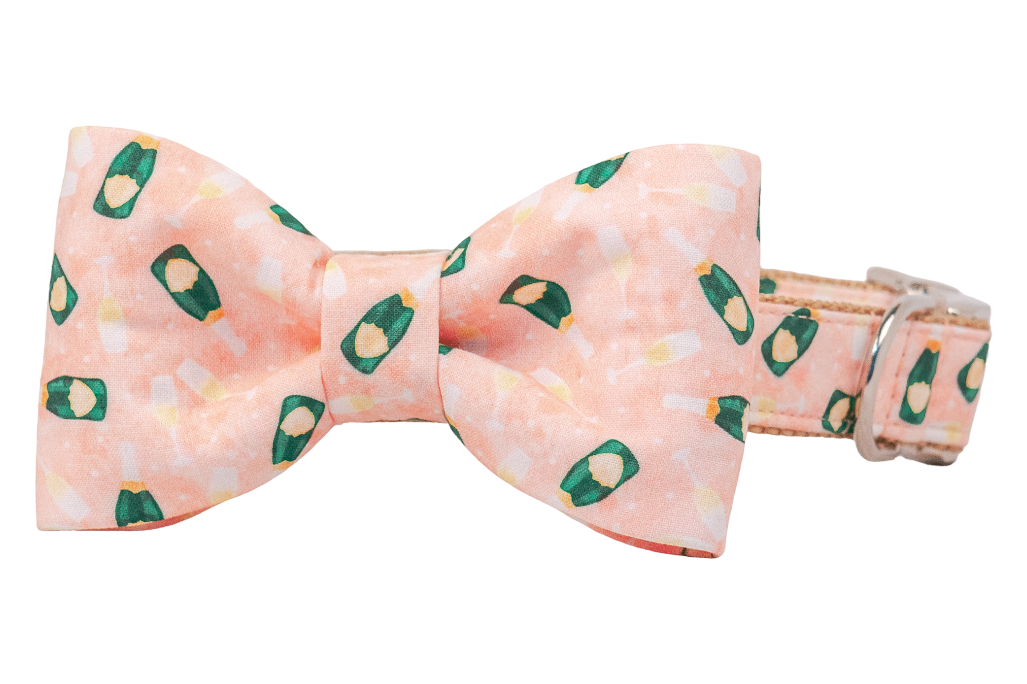 A structured dog bow tie in blush pink, attached to a matching collar. The bow tie and collar feature a festive repeating print of green champagne bottles and golden glasses against a soft pink background. The collar includes silver hardware, including a loop for attaching a leash or tag.