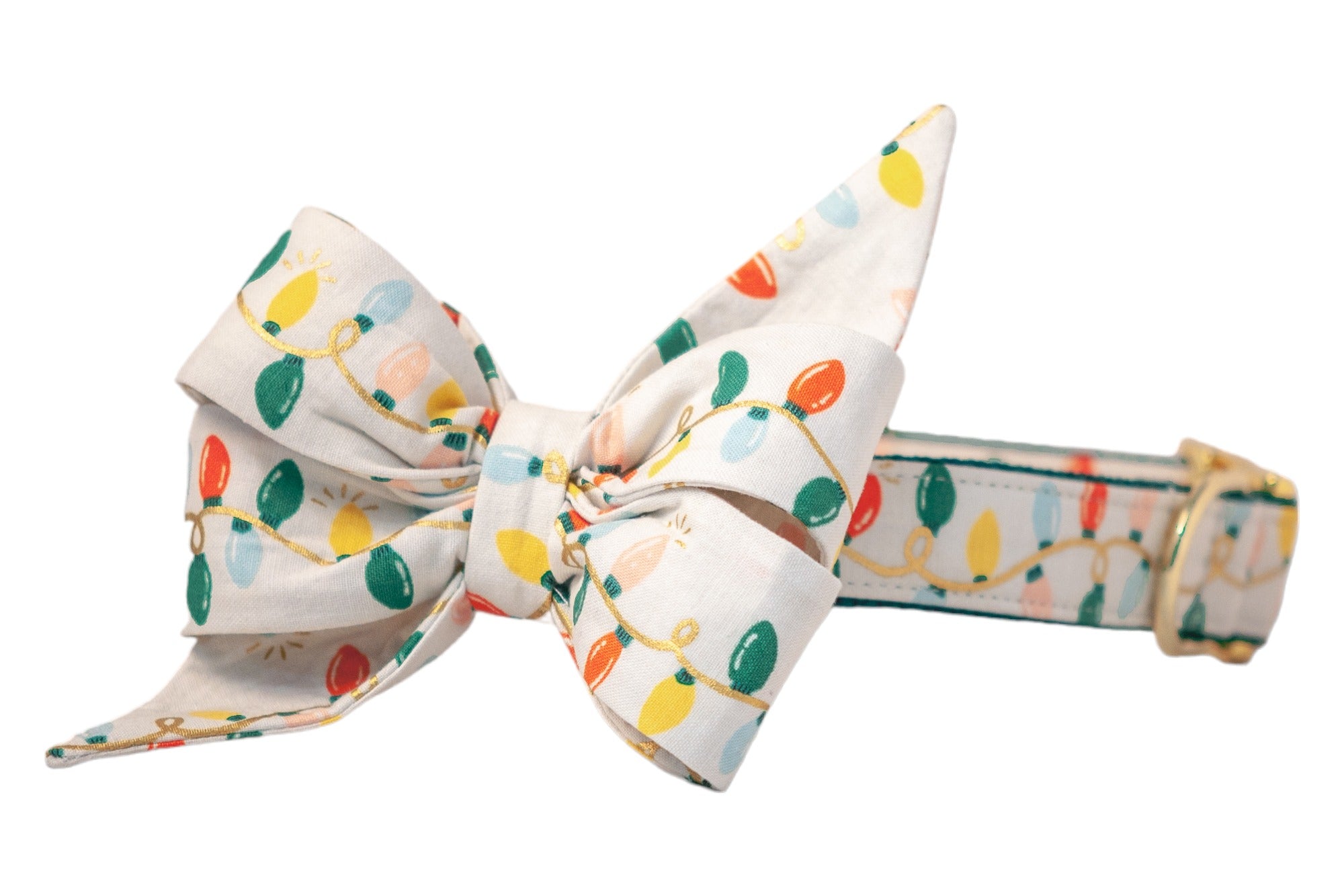 A festive dog collar featuring an oversized, pointed belle bow made from cream-colored fabric printed with colorful string lights. The design includes red, green, yellow, blush, and blue bulbs connected by metallic wires. The collar has an adjustable strap and a polished buckle.