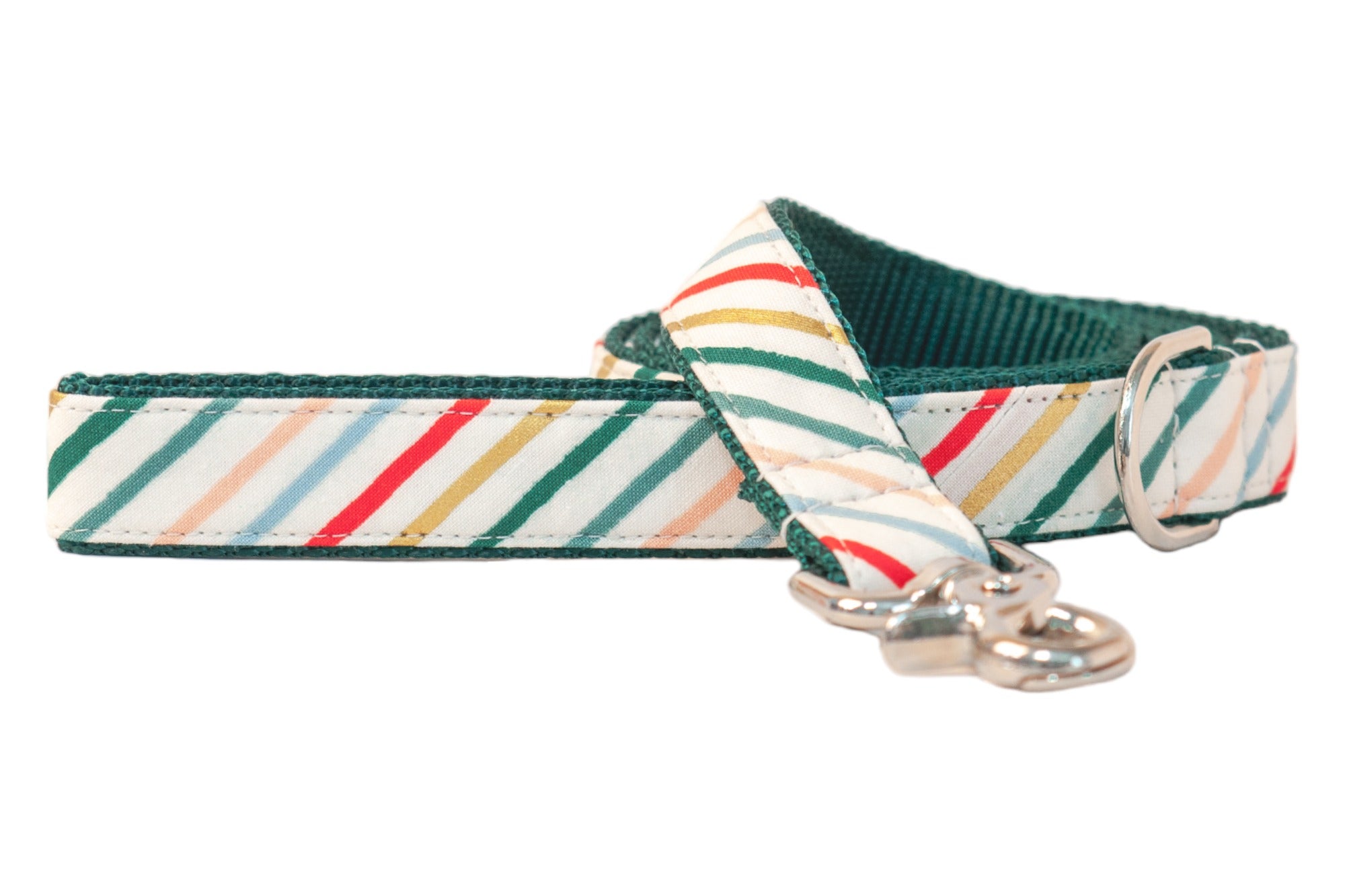 A festive dog leash featuring diagonal candy cane–inspired stripes in green, red, gold, blue, and blush on a cream background. The leash is lined with dark green webbing for durability and finished with a metal clasp and D-ring.