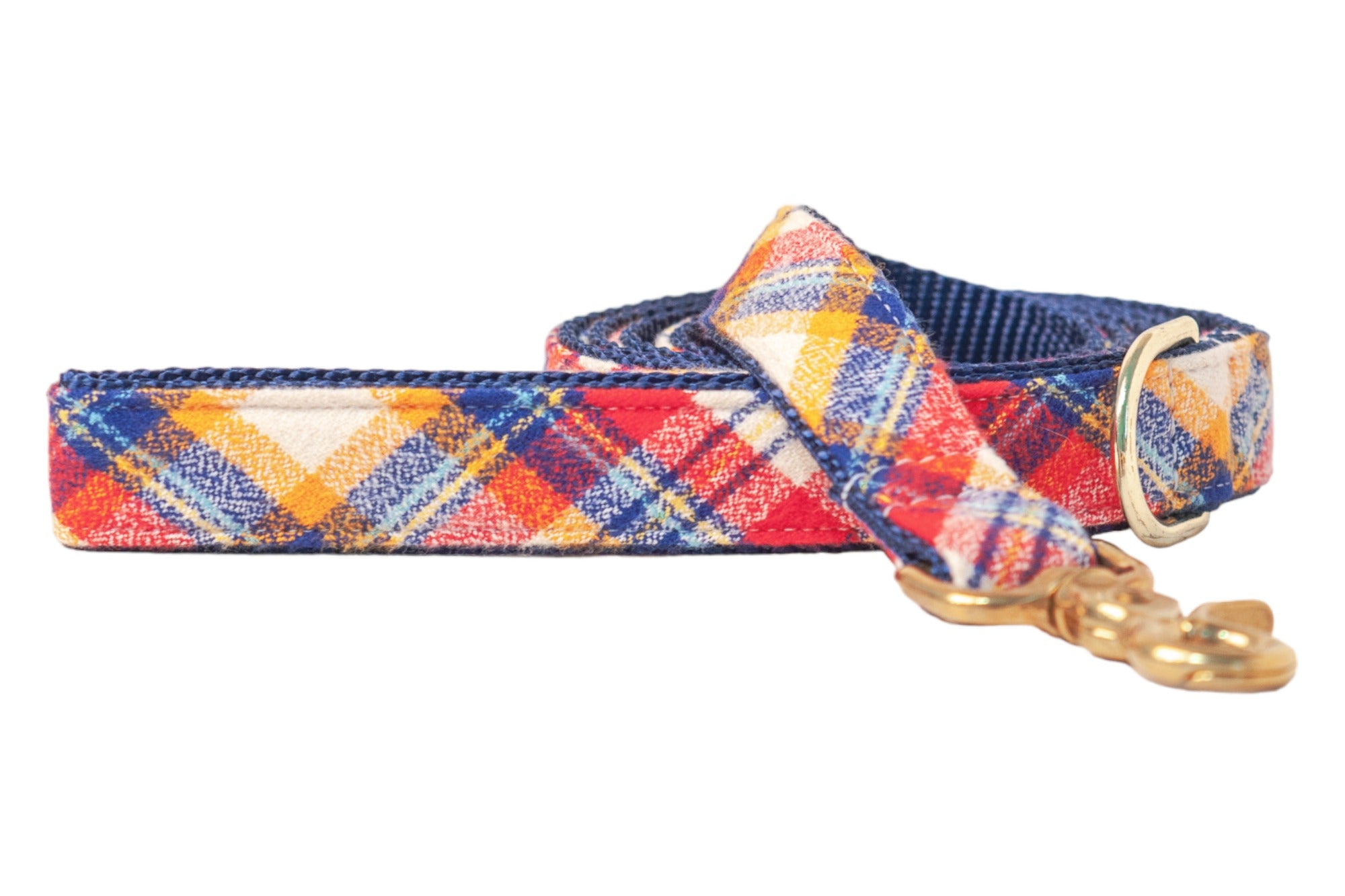 Plaid dog leash made with a soft flannel fabric in rich tones. The leash is shown coiled with a dark nylon underside and finished with polished hardware, giving it a cozy, seasonal look ideal for autumn walks.