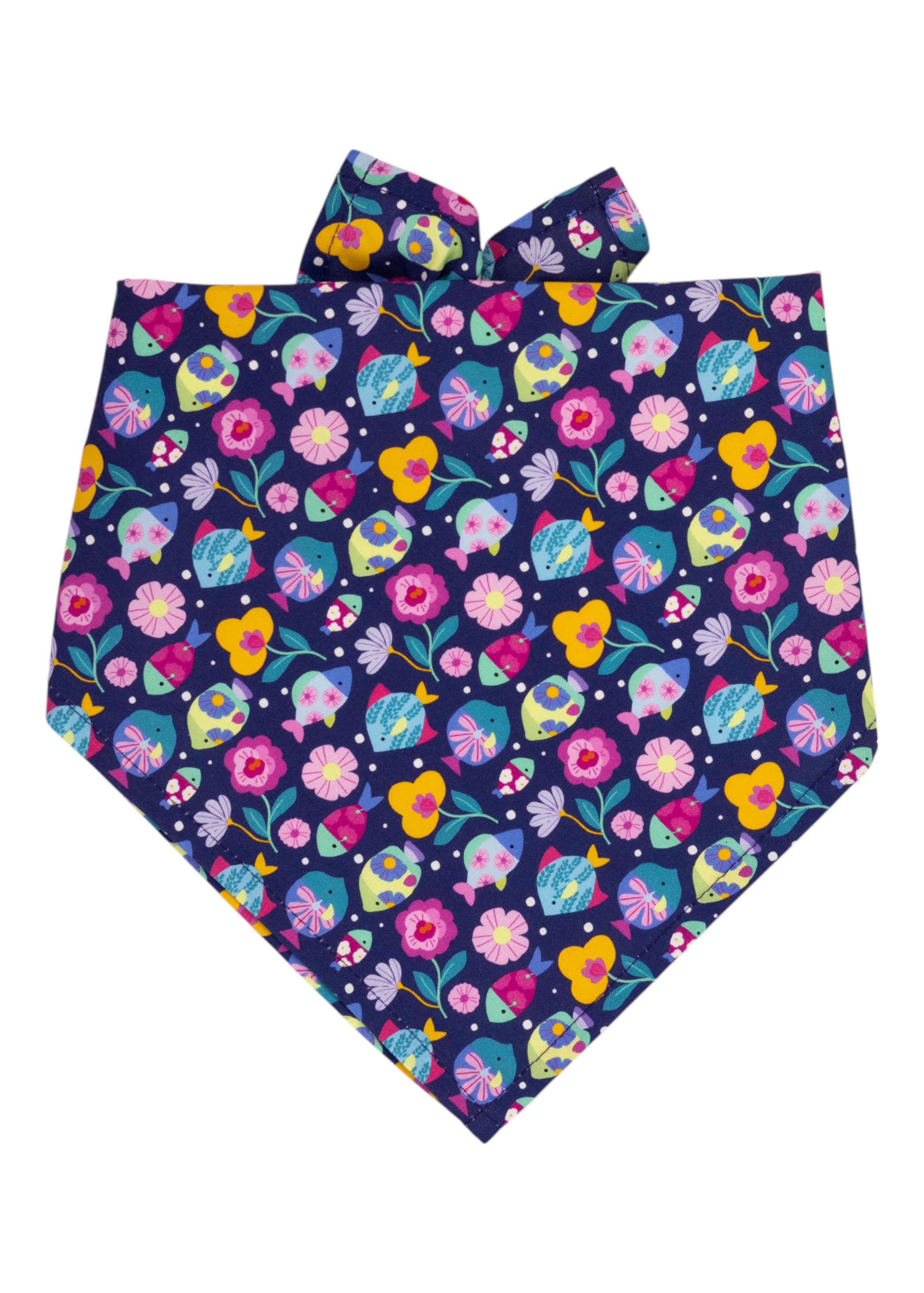 Whimsical dog bandana in dark blue, decorated with bright illustrations of fish, floral patterns, and scattered white dots. The fabric is neatly folded into a triangular design with tied ends.