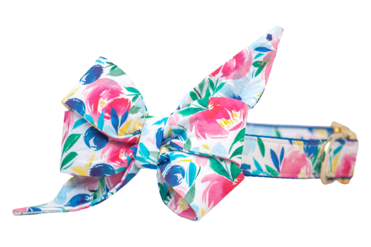 Floral dog collar featuring a dramatic, structured belle bow with pointed tails. The fabric displays colorful blooms in shades of pink, deep blue, and yellow, with green leafy accents. The collar matches the belle bow’s pattern and is fastened with polished gold metal hardware.