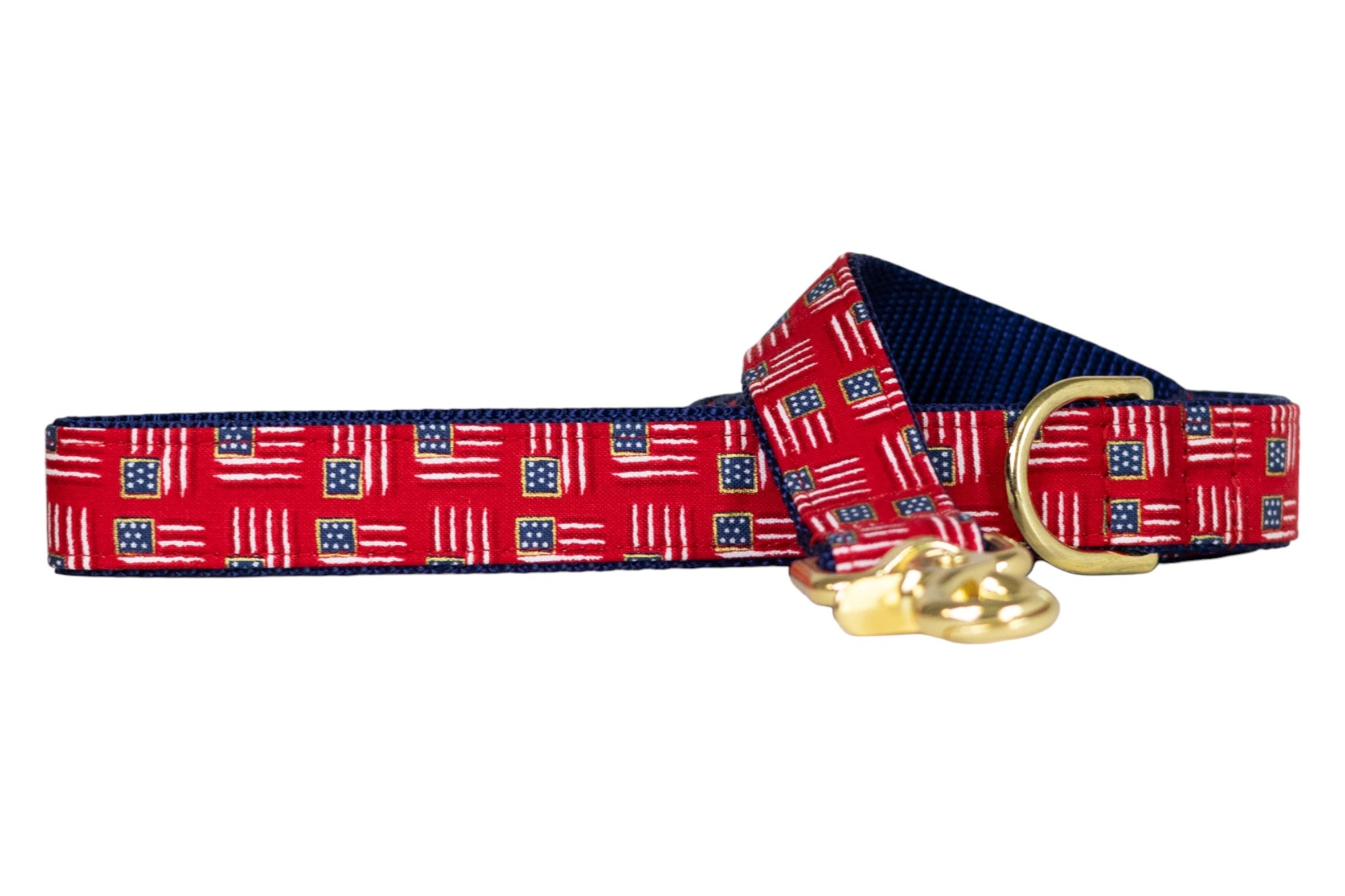 Patriotic-themed red dog leash decorated with miniature American flags, paired with a navy blue underside, a gold D-ring, and a brass clip for easy fastening.