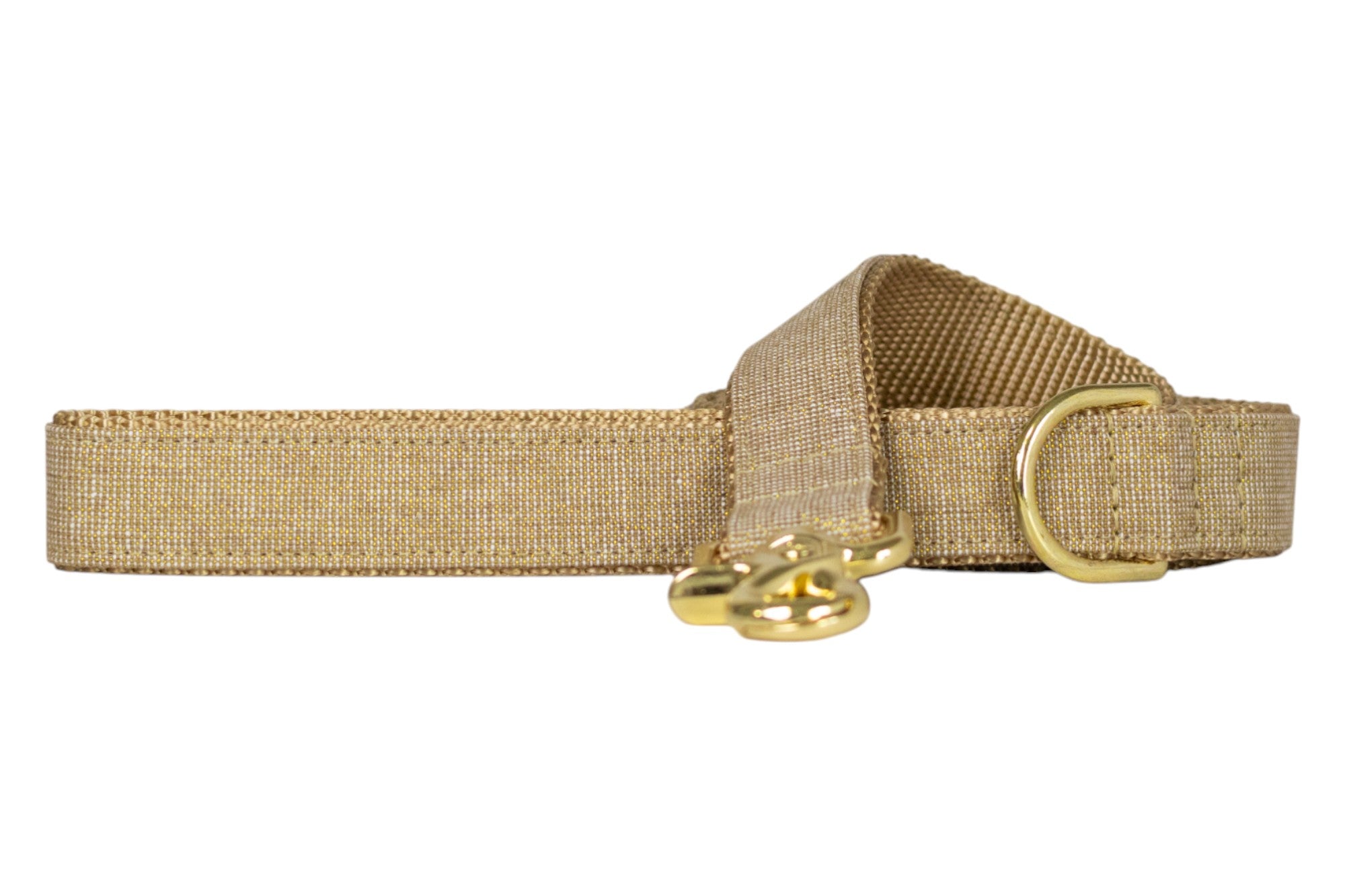 Dog leash made from shimmering metallic gold fabric with a woven texture, layered over durable nylon webbing. Features reinforced stitching along the edges, a comfortable matching gold-finished handle loop, and a polished gold swivel snap hook for secure collar attachment. A coordinating gold D-ring is positioned near the handle for clipping accessories like waste bag holders or keys.