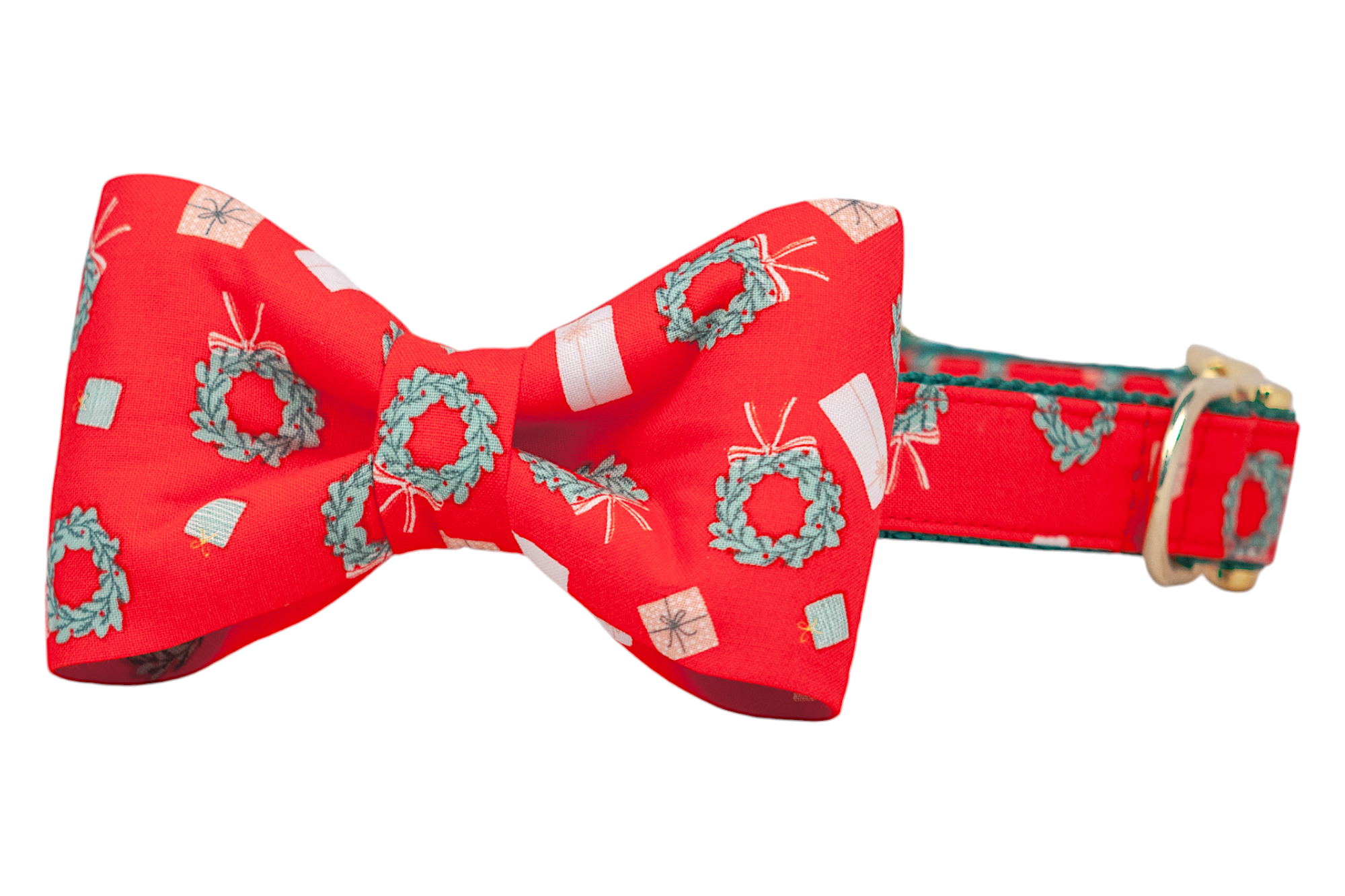 Holiday dog collar with an attached matching bow tie, made of red fabric printed with holiday wreaths and wrapped presents in soft pastel tones. The collar is equipped with polished hardware, giving the cheerful design a refined finish.