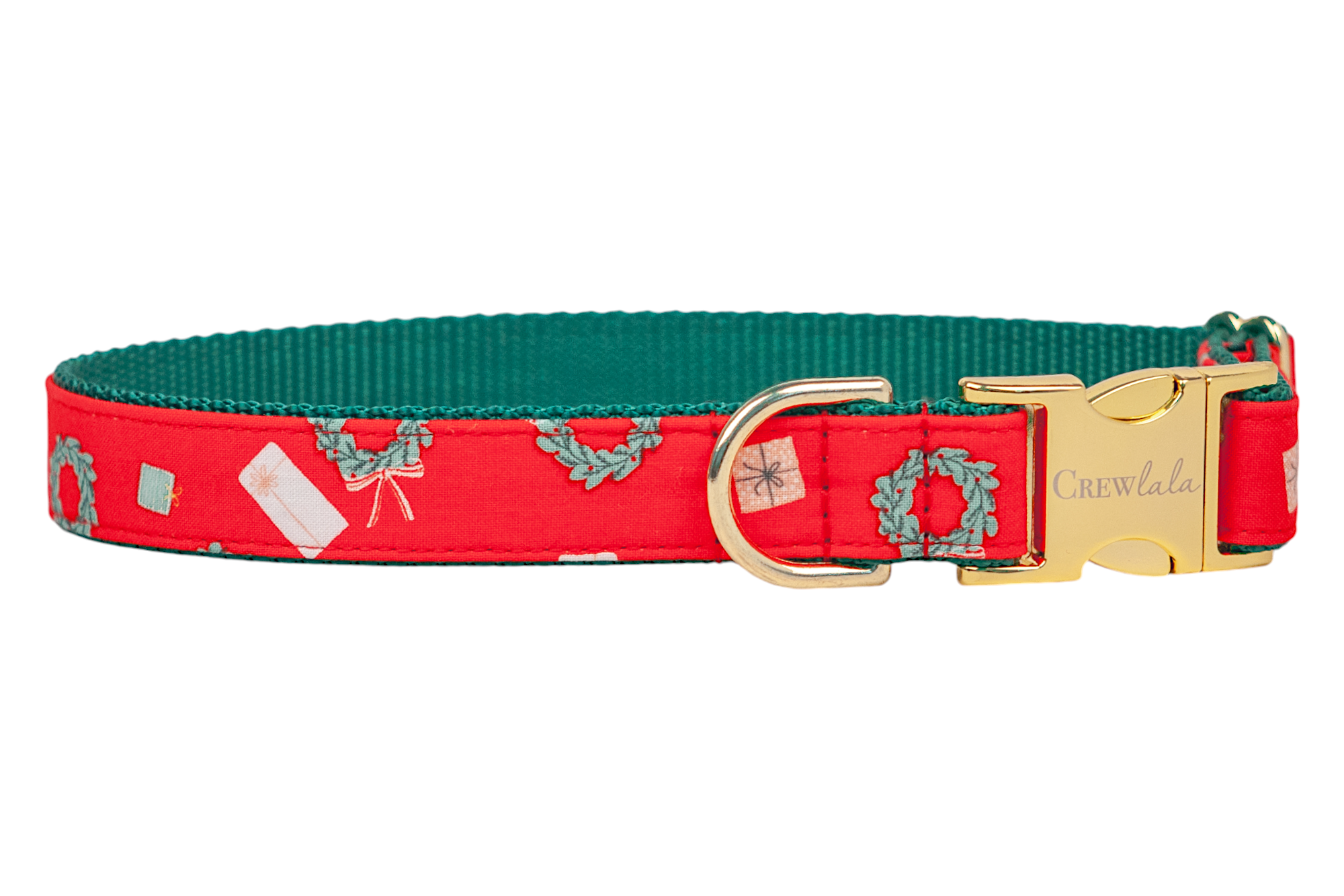 A festive red dog collar decorated with a holiday print of wreaths, wrapped gifts, and tags. The collar is backed with contrasting webbing and features polished hardware, including a D-ring and a side-release buckle engraved with the brand name “Crewlala.”