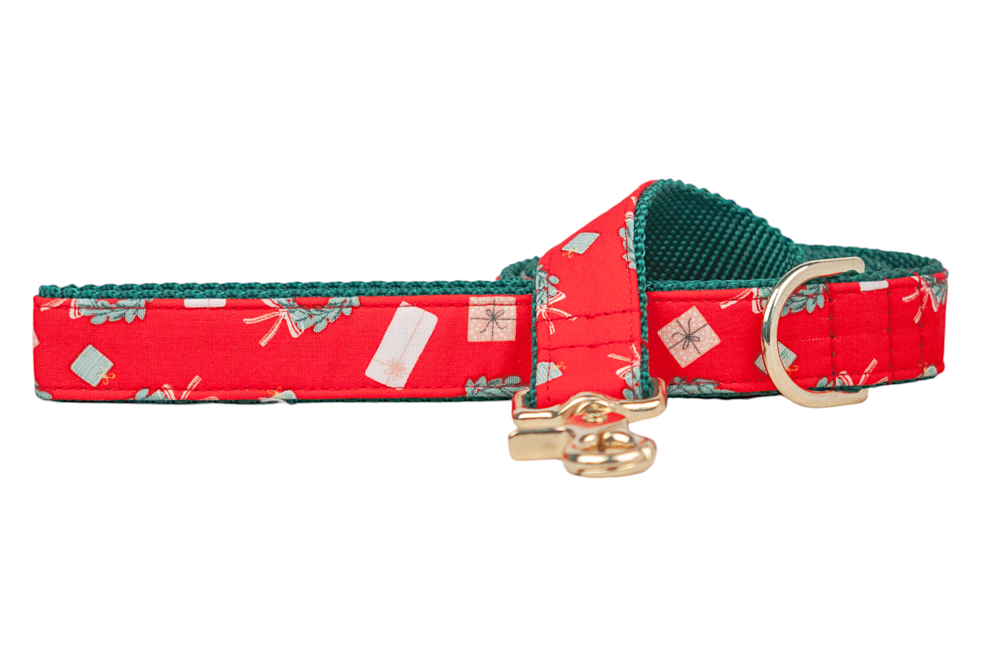 Christmas dog leash made from red fabric with miniature gift packages and holiday foliage, accented with a contrasting inner lining. The leash has a D-ring and a matching swivel snap hook.