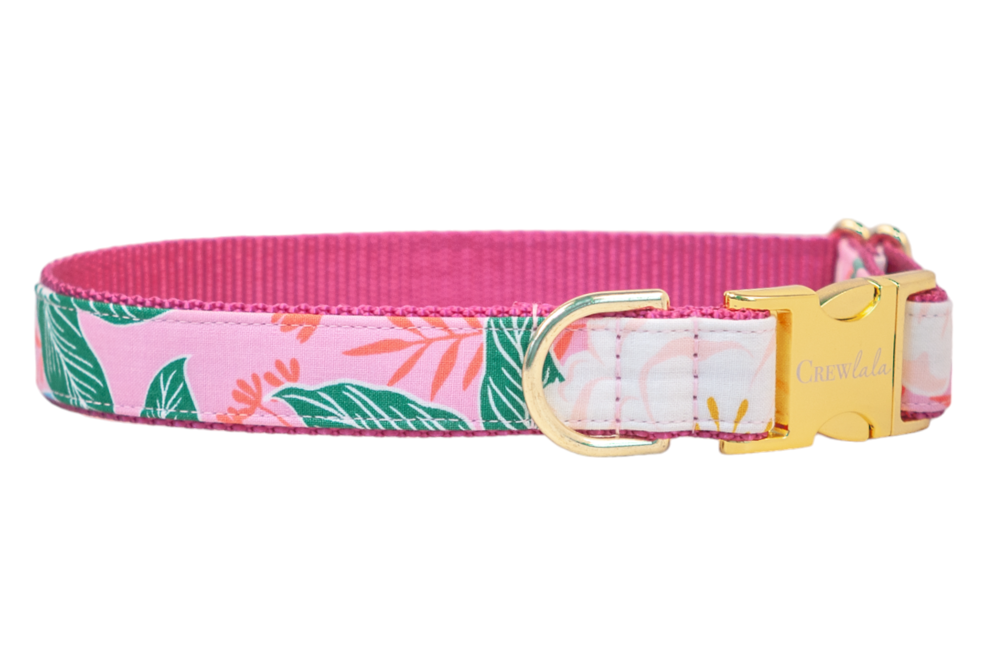 A vibrant pink dog collar featuring a tropical floral print with white blossoms, green leaves, and coral orange stems on a soft pink background, accented by a hot pink woven underside and a gold-tone buckle engraved with "Crewlala."
