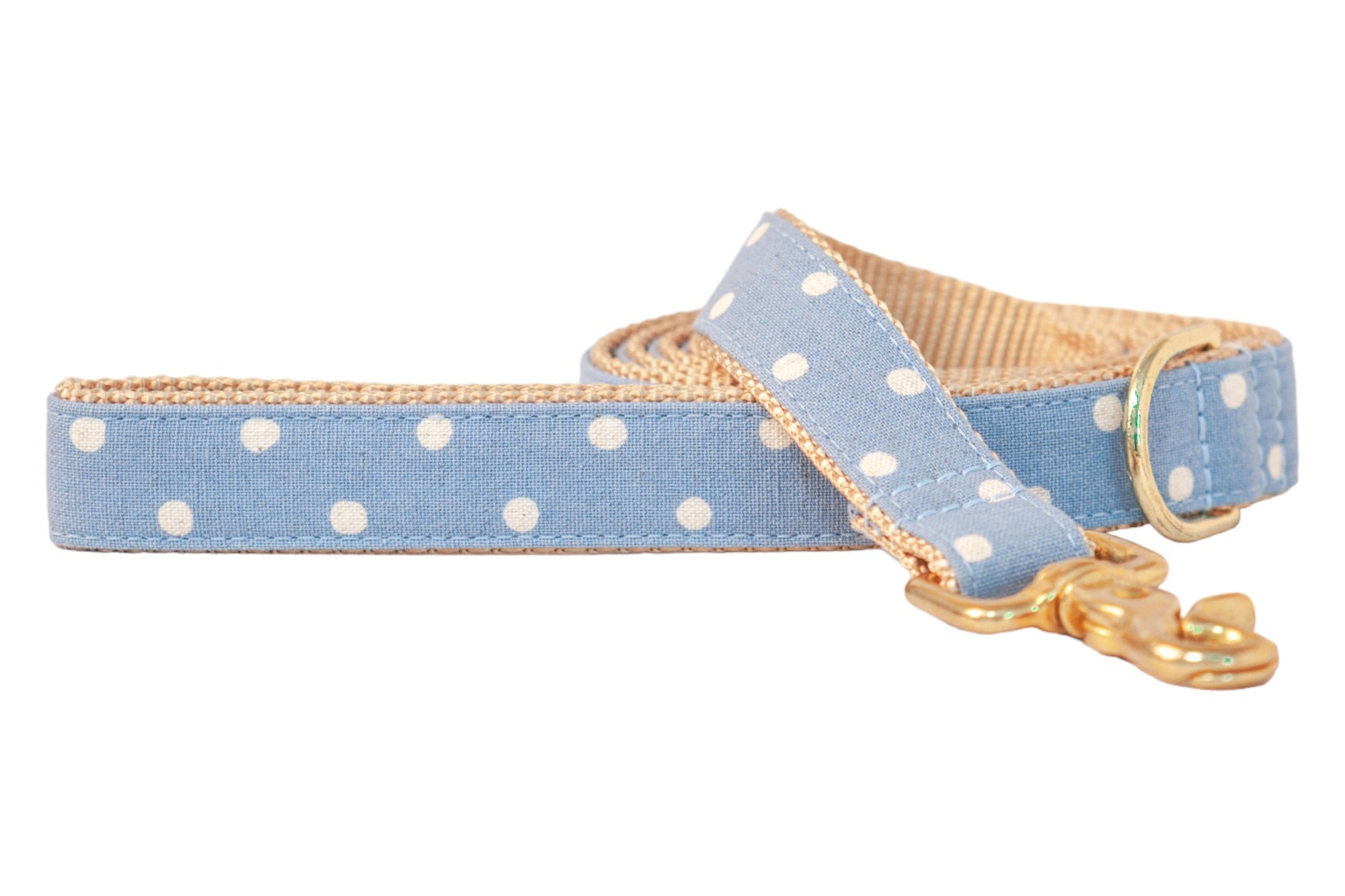 Stylish dog leash in soft blue with playful white polka dots, finished with tan webbing on the interior and gold-tone hardware including a sturdy swivel clasp.