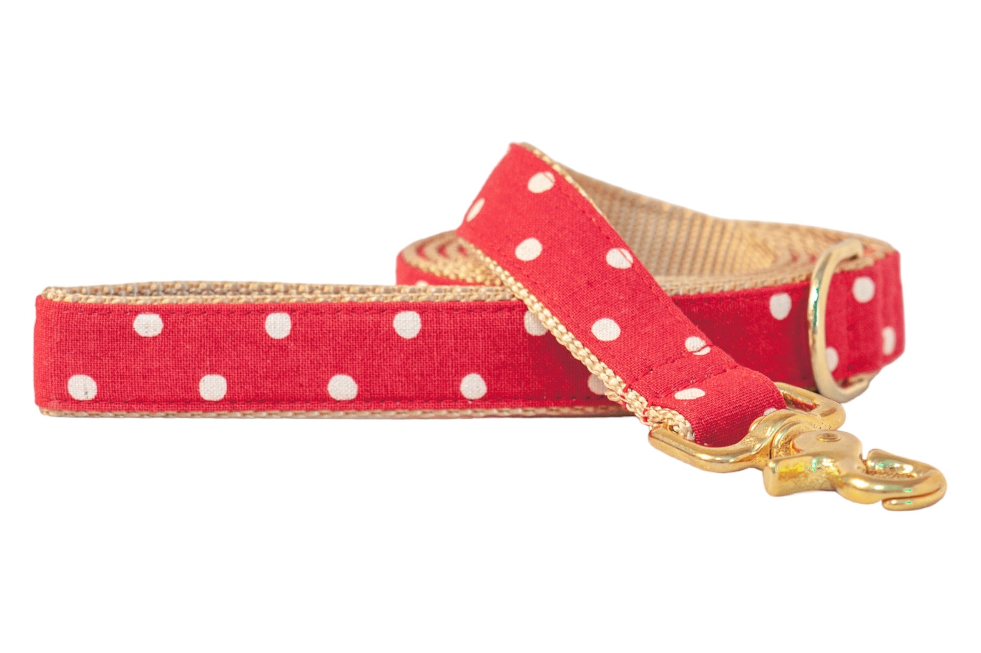 Stylish dog leash in red with playful white polka dots, finished with tan webbing trim and gold-tone hardware including a sturdy swivel clasp.