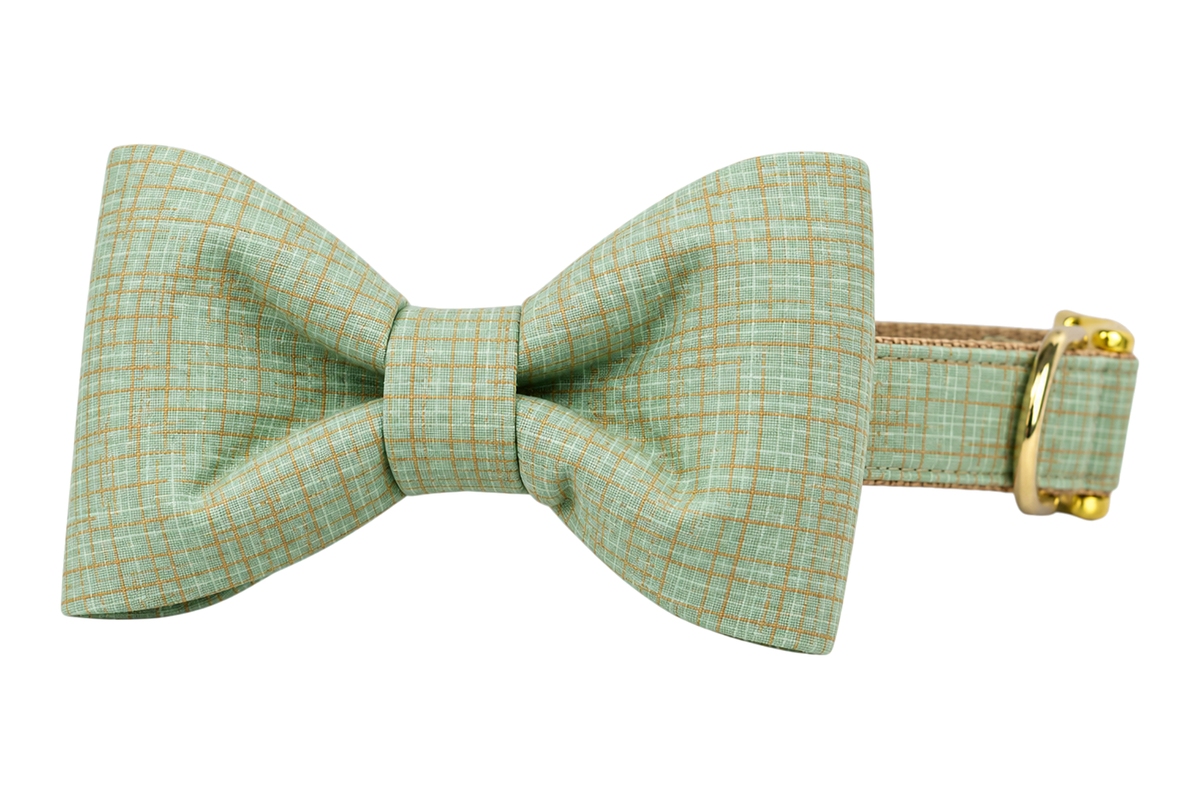 Classic dog collar featuring a Jadeite Green fabric bow tie, a soft jadeite mint green linen with a fine tonal plaid weave, attached to a matching Jadeite Green collar with a nylon inner lining and gleaming gold hardware, including a D-ring and buckle.