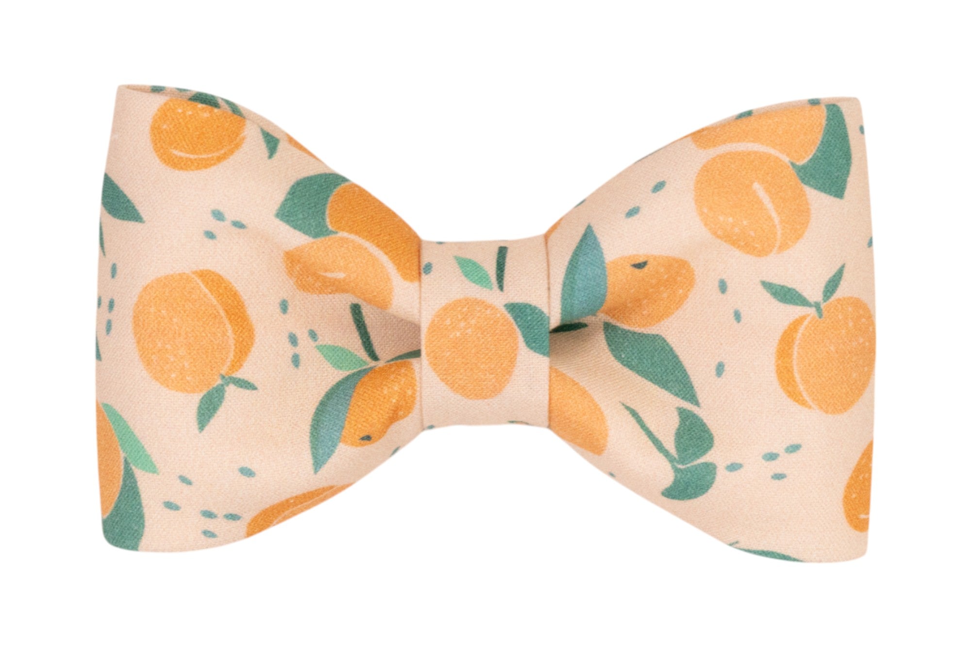 Peach-toned dog bow tie featuring a orangey and green print with illustrated peaches, leafy sprigs, and decorative speckling.