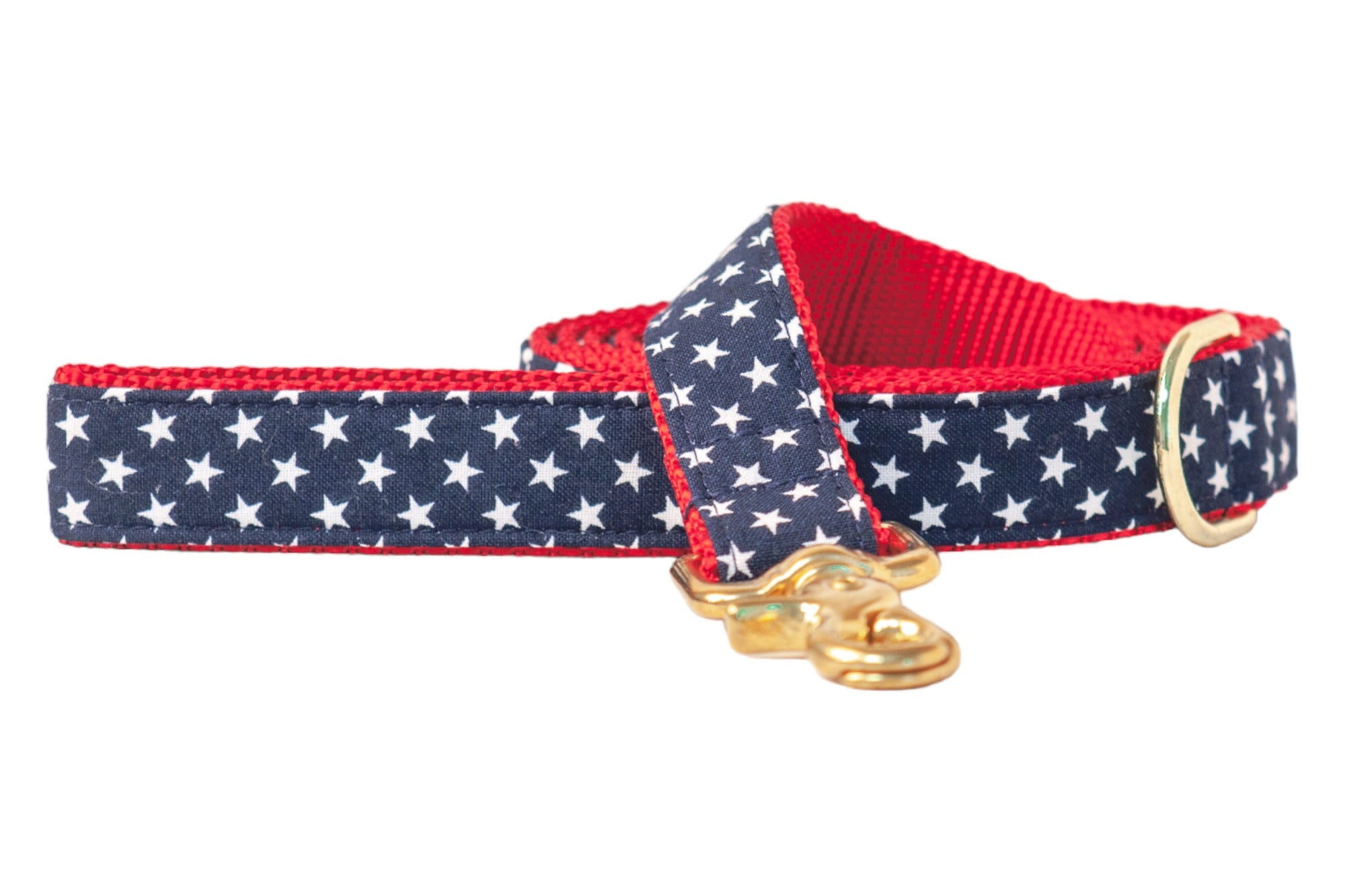 Close-up of a patriotic dog leash with a star-spangled navy blue design and bold red lining. The set is accented with shiny gold hardware, including a swivel leash clasp and D-ring for leash attachment.