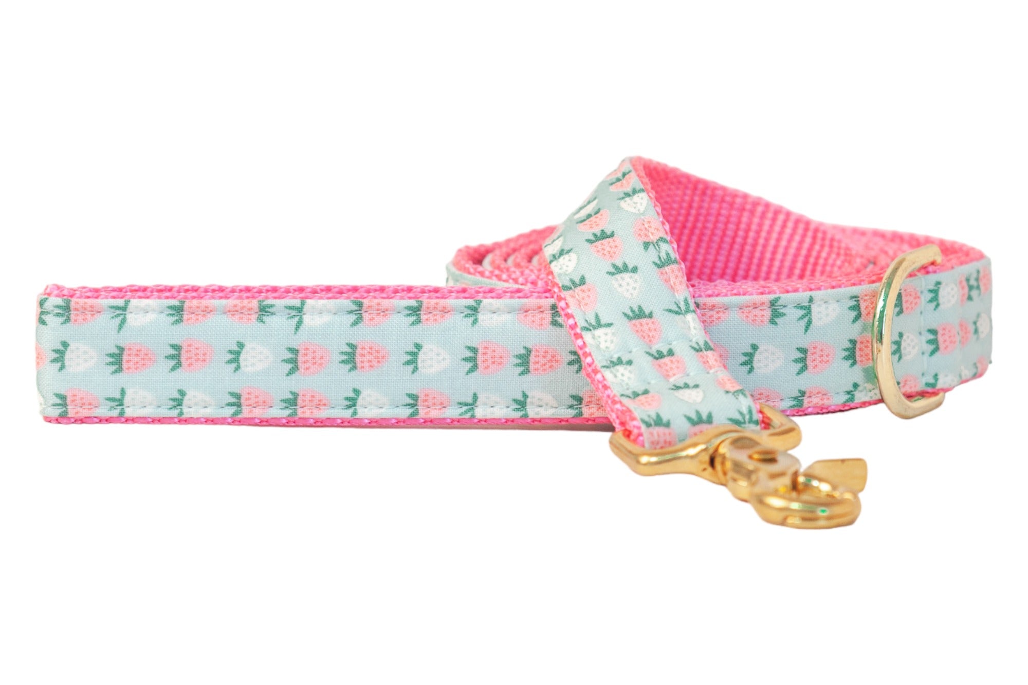 Dog leash with a pastel mint background and a repeating pink and white strawberry pattern, featuring bright pink backing and shiny gold hardware.