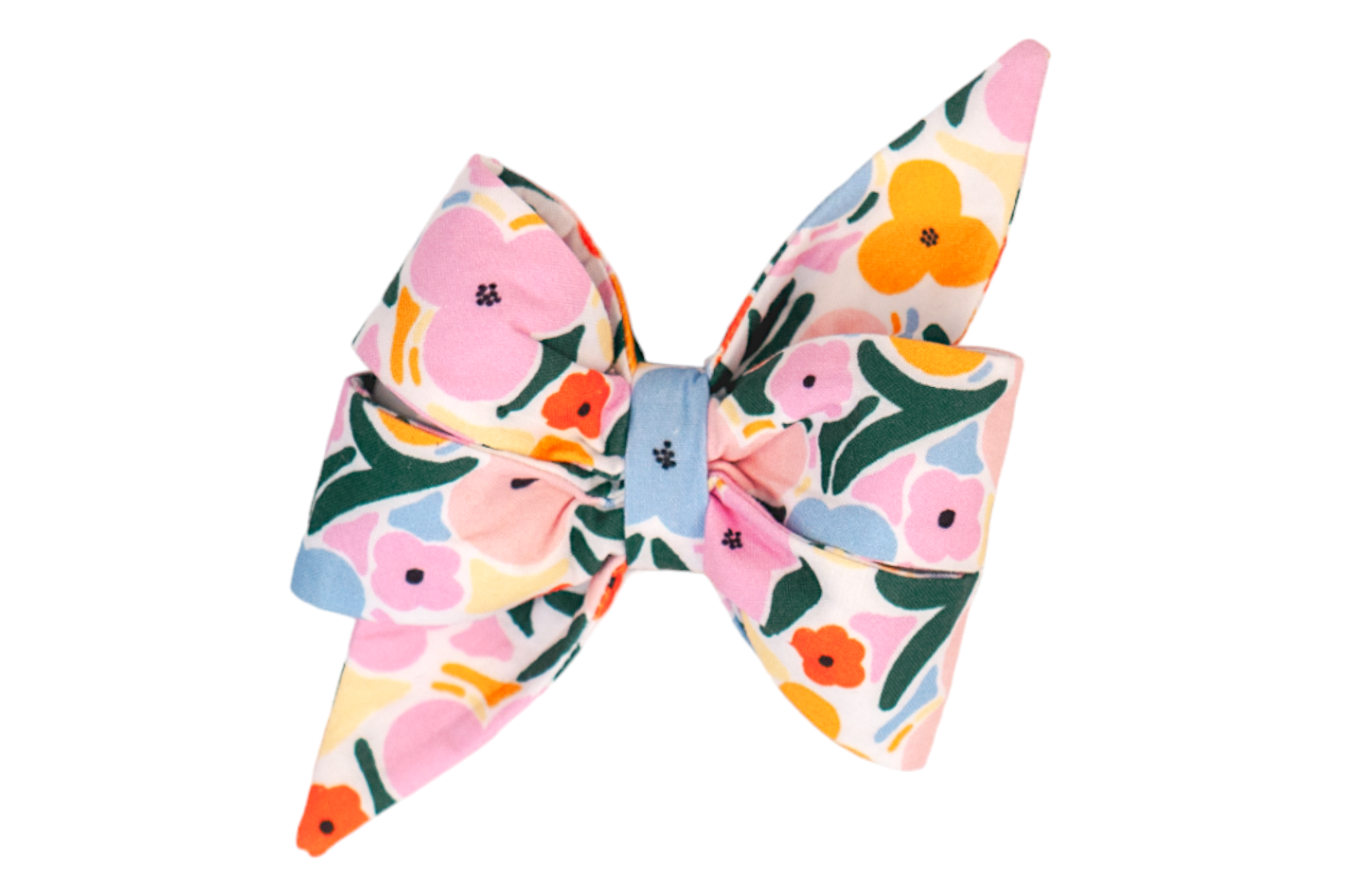 A vibrant dog belle bow with two layered loops and pointed tails, crafted from a fabric printed with large stylized flowers in pastel pink, bright yellow, orange, and light blue, accented by deep green leafy shapes. The bow is cinched in the middle with a matching floral fabric strip, creating a cheerful, springtime look.