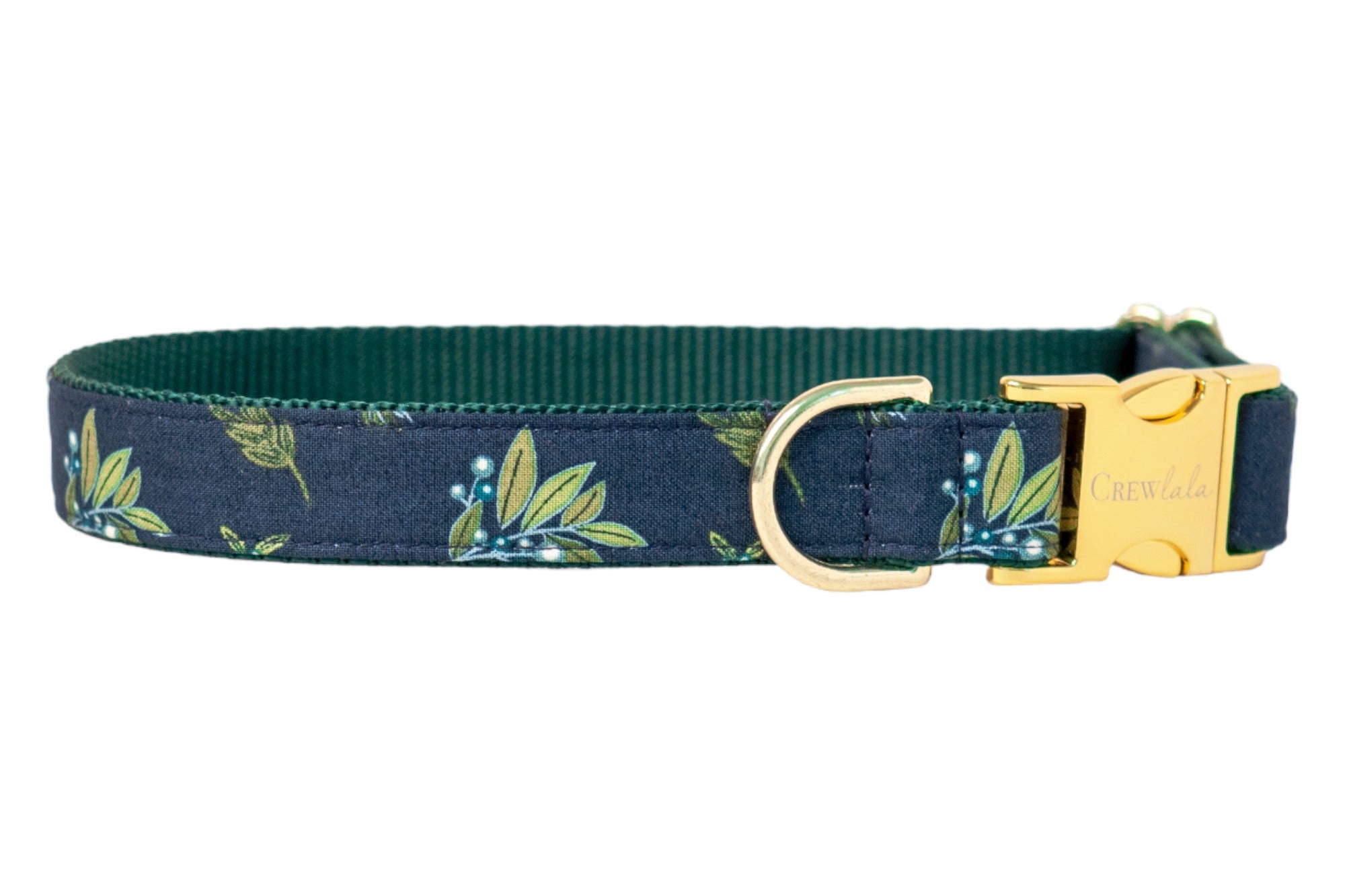 Stylish dog collar in dark blue with a leafy botanical print, paired with a dark inner webbing and metal hardware, including a buckle engraved with “Crew Lala.”