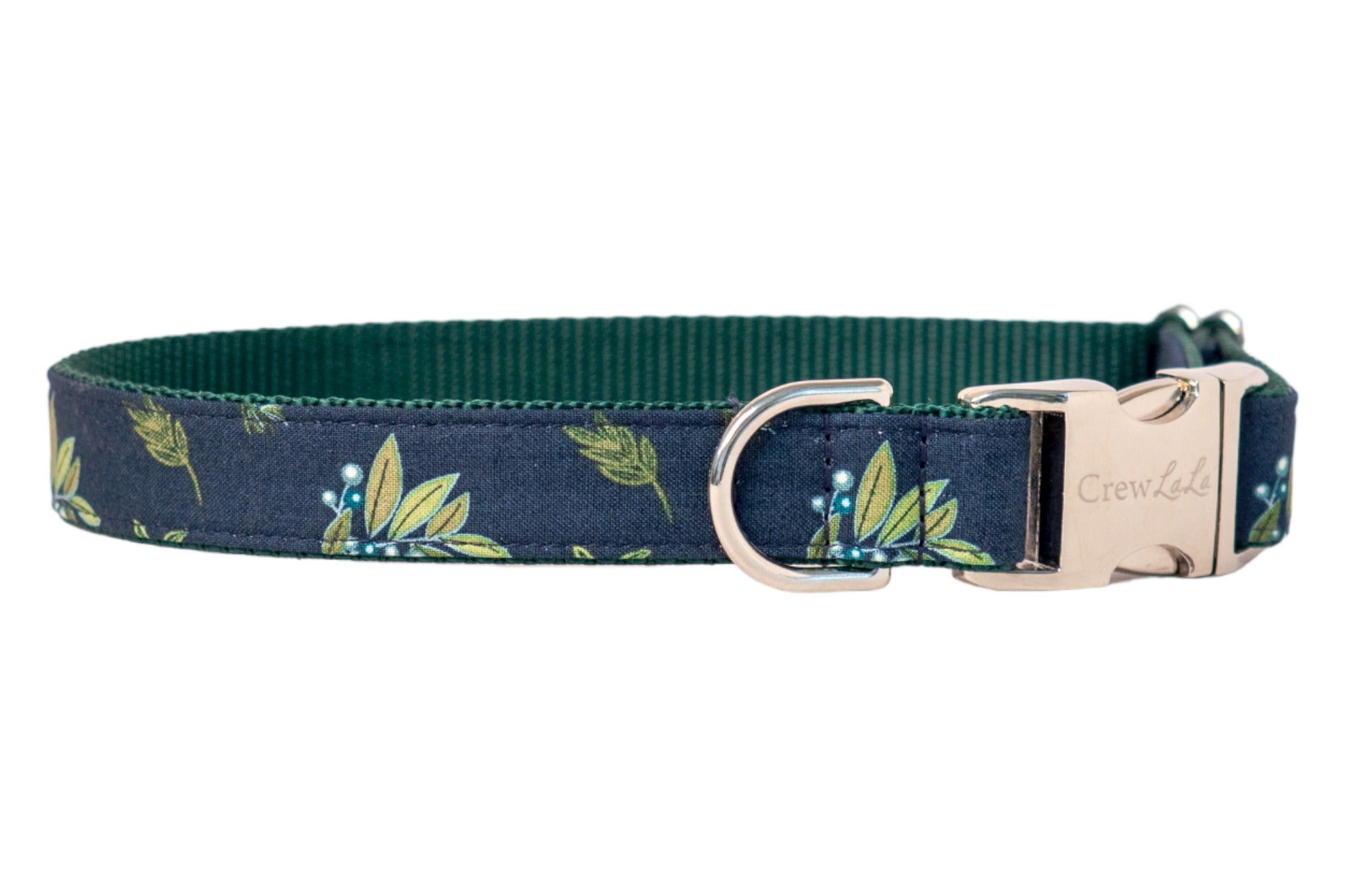 Stylish dog collar in dark blue with a leafy botanical print, paired with a dark inner webbing and metal hardware, including a buckle engraved with “Crew Lala.”