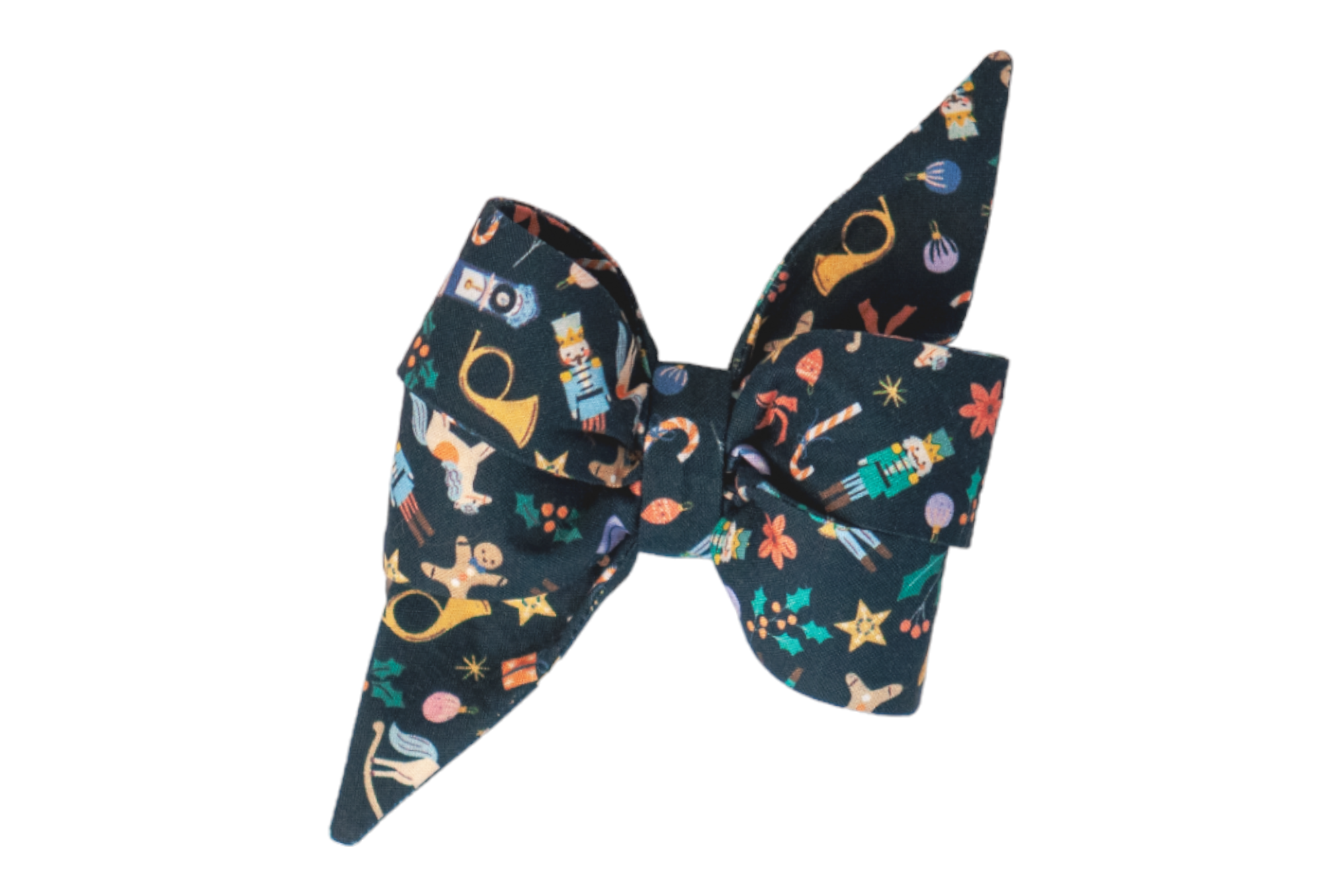 Dog belle bow with pointed tails made of navy blue fabric, printed with detailed Christmas-themed illustrations including nutcrackers, rocking horses, gingerbread men, holly leaves, French horns, candy canes, stars, and ornaments in vibrant holiday colors