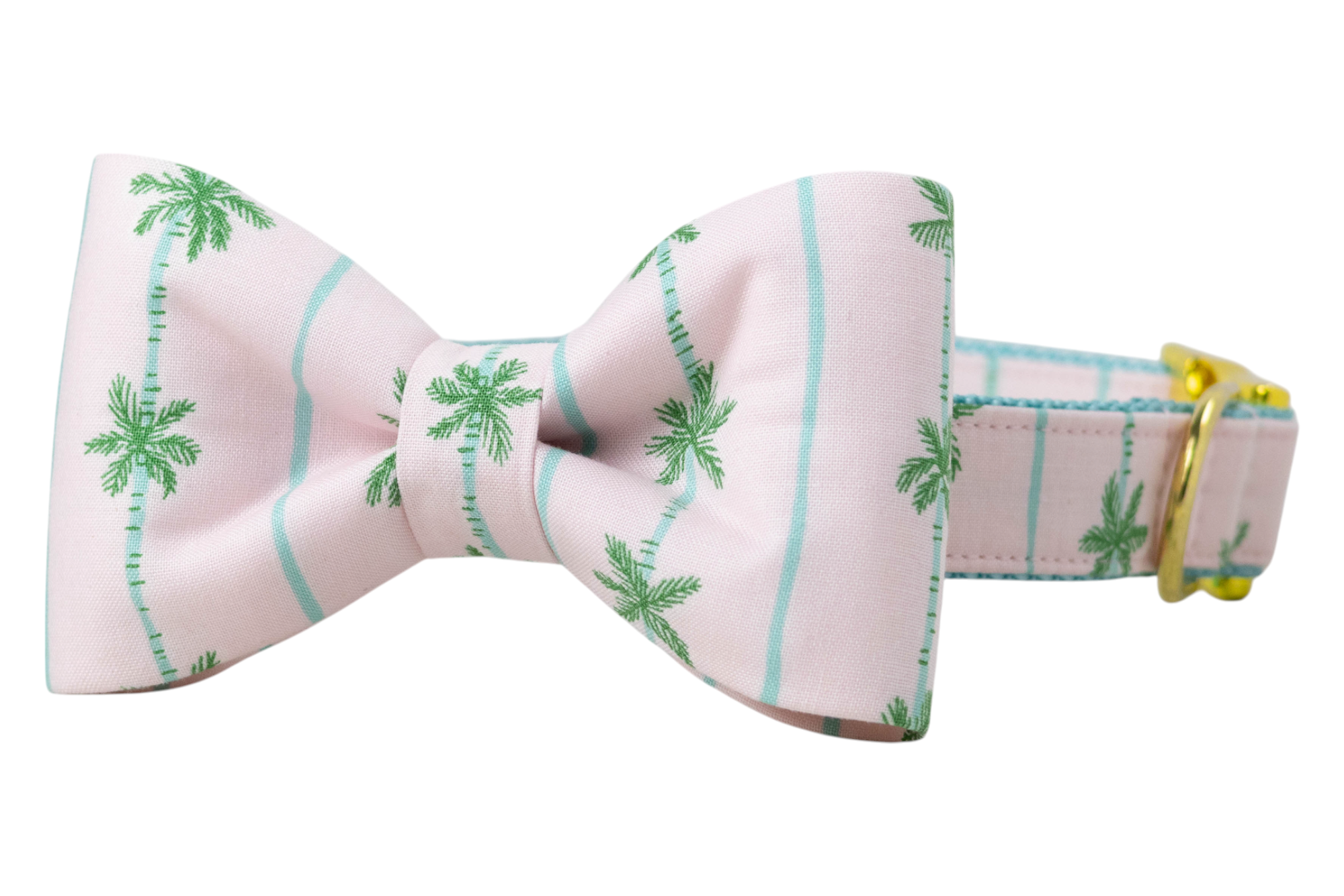 Tropical-themed dog collar with an attached structured and matching bow tie, designed in light pink with green palm trees and aqua blue vertical lines. Gold hardware accents complete the look.