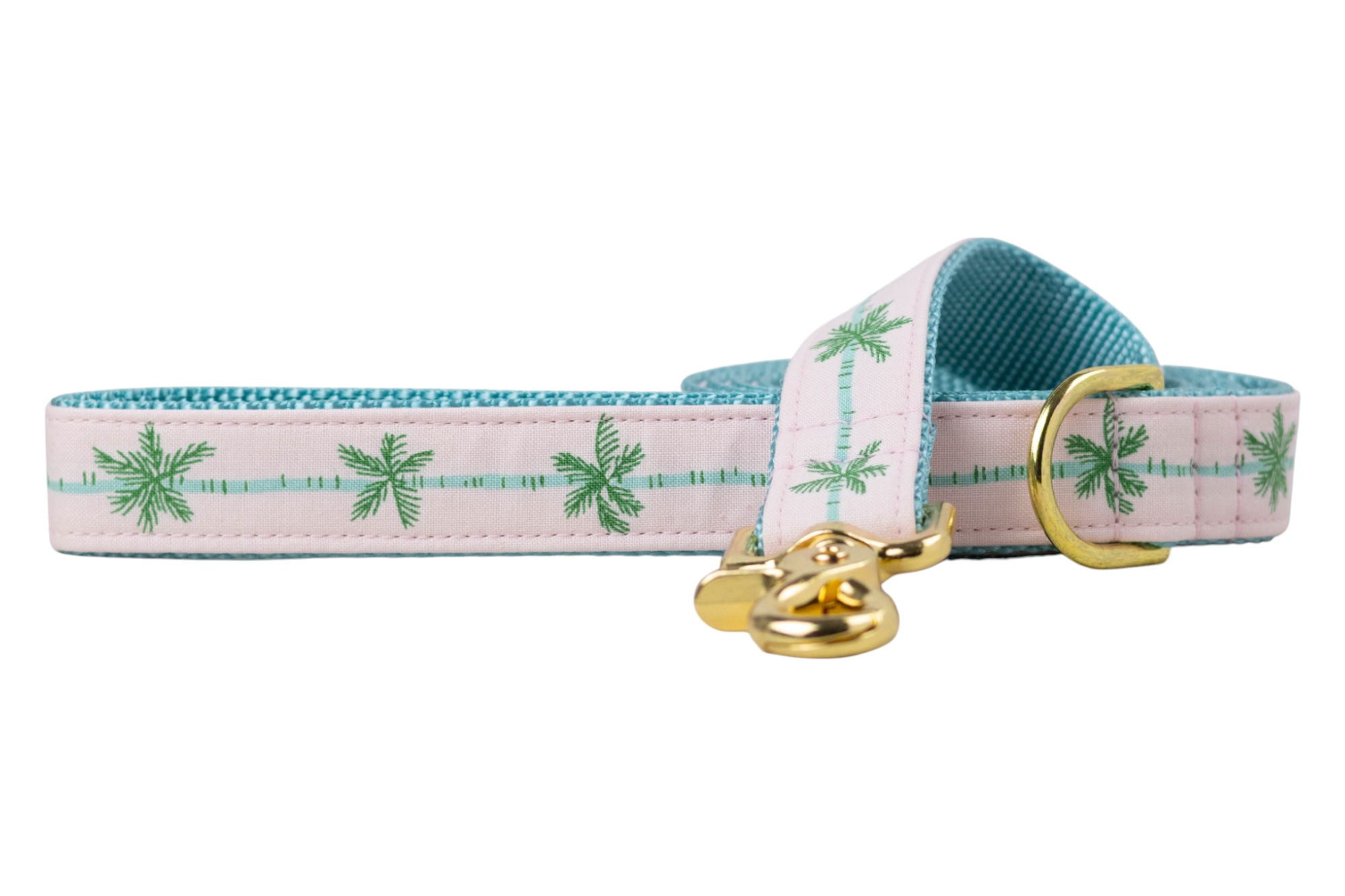 ropical-themed dog leash with a pink fabric overlay printed with green palm trees and aqua blue lines, backed by teal woven material and finished with shiny gold-tone hardware.