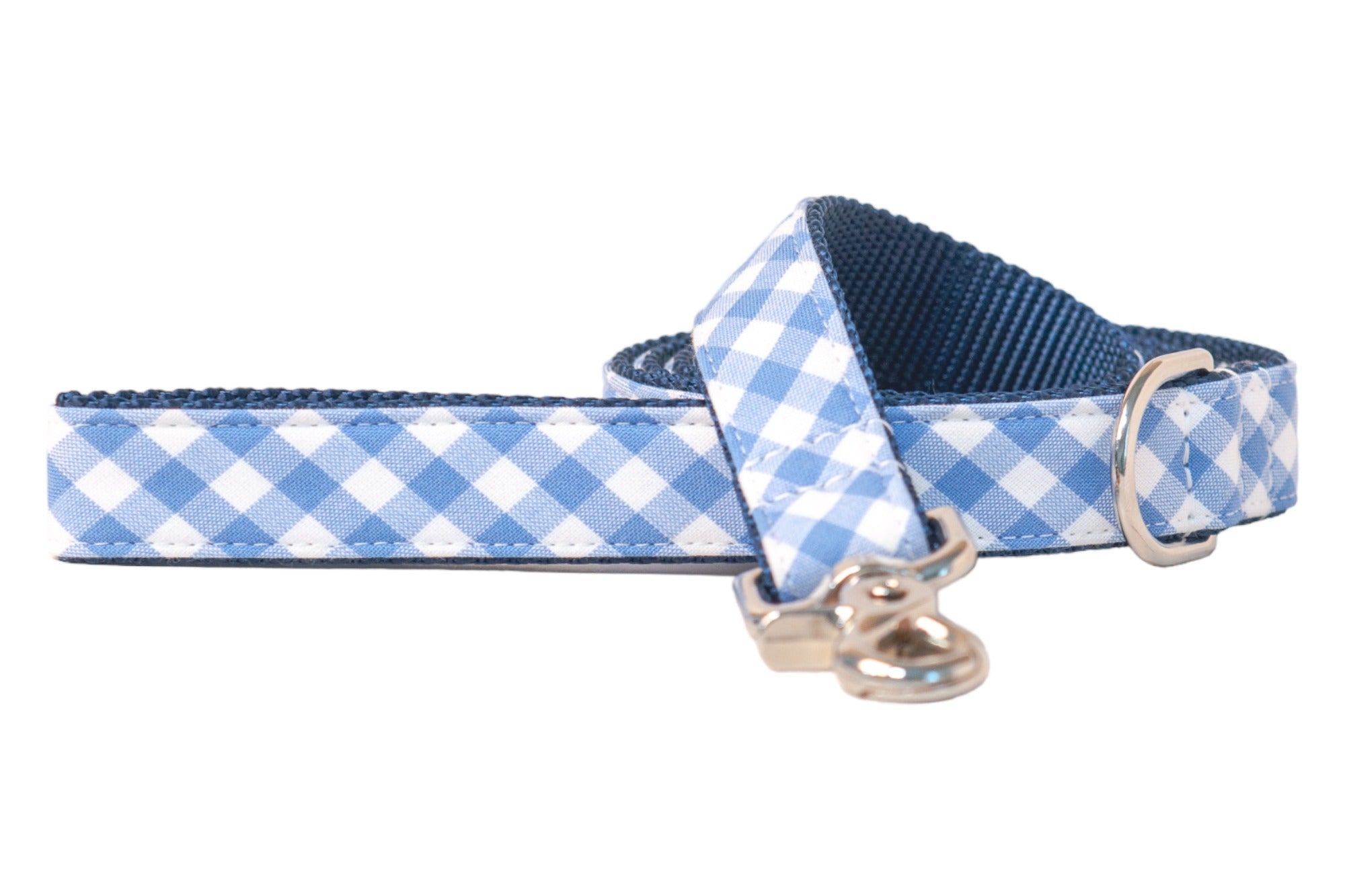 Dog leash with a periwinkle plaid print and dark blue woven underside, finished with a polished silver clip hook and a metal D-ring at the base of the handle loop. The pattern runs along the length of the leash for a stylish and classic look.