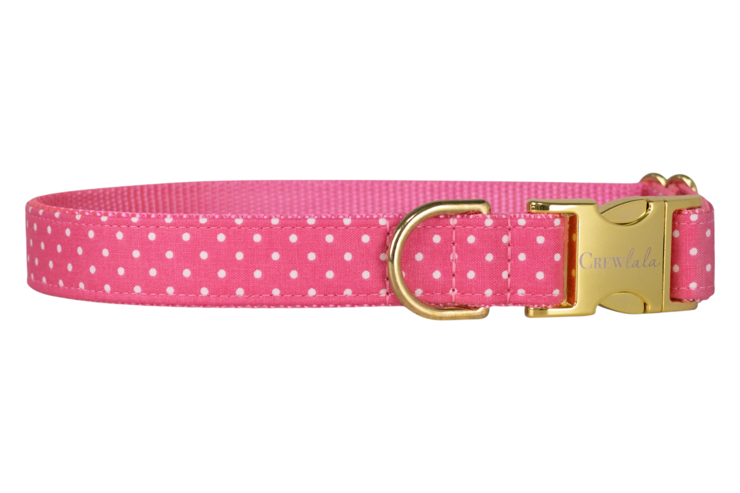Bright pink adjustable dog collar patterned with small white polka dots, paired with a gold clasp and D-ring for leash attachment.