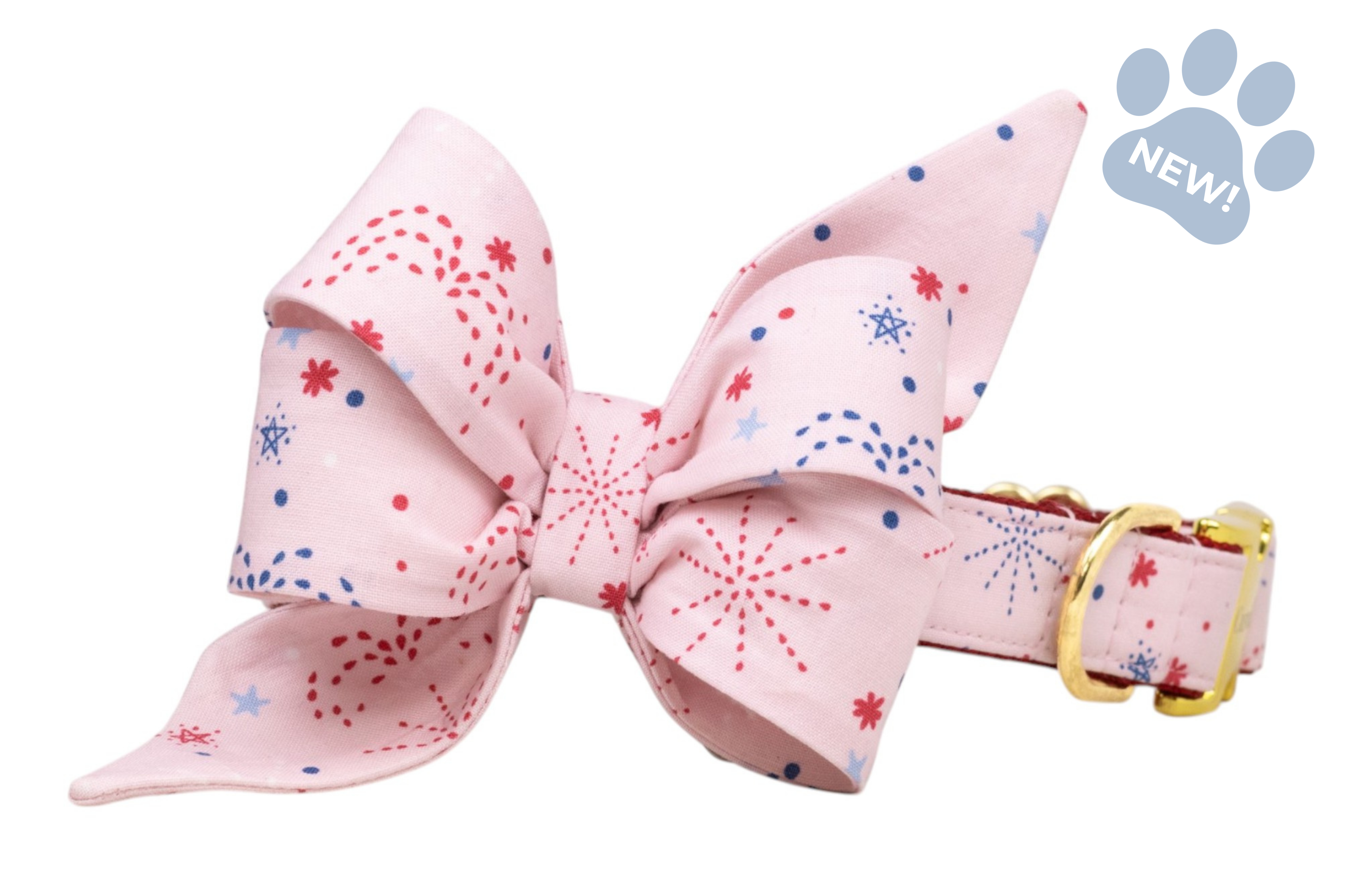 Soft pink collar with an oversized bow, printed with red and blue firework bursts and dots, paired with a gold-tone buckle.