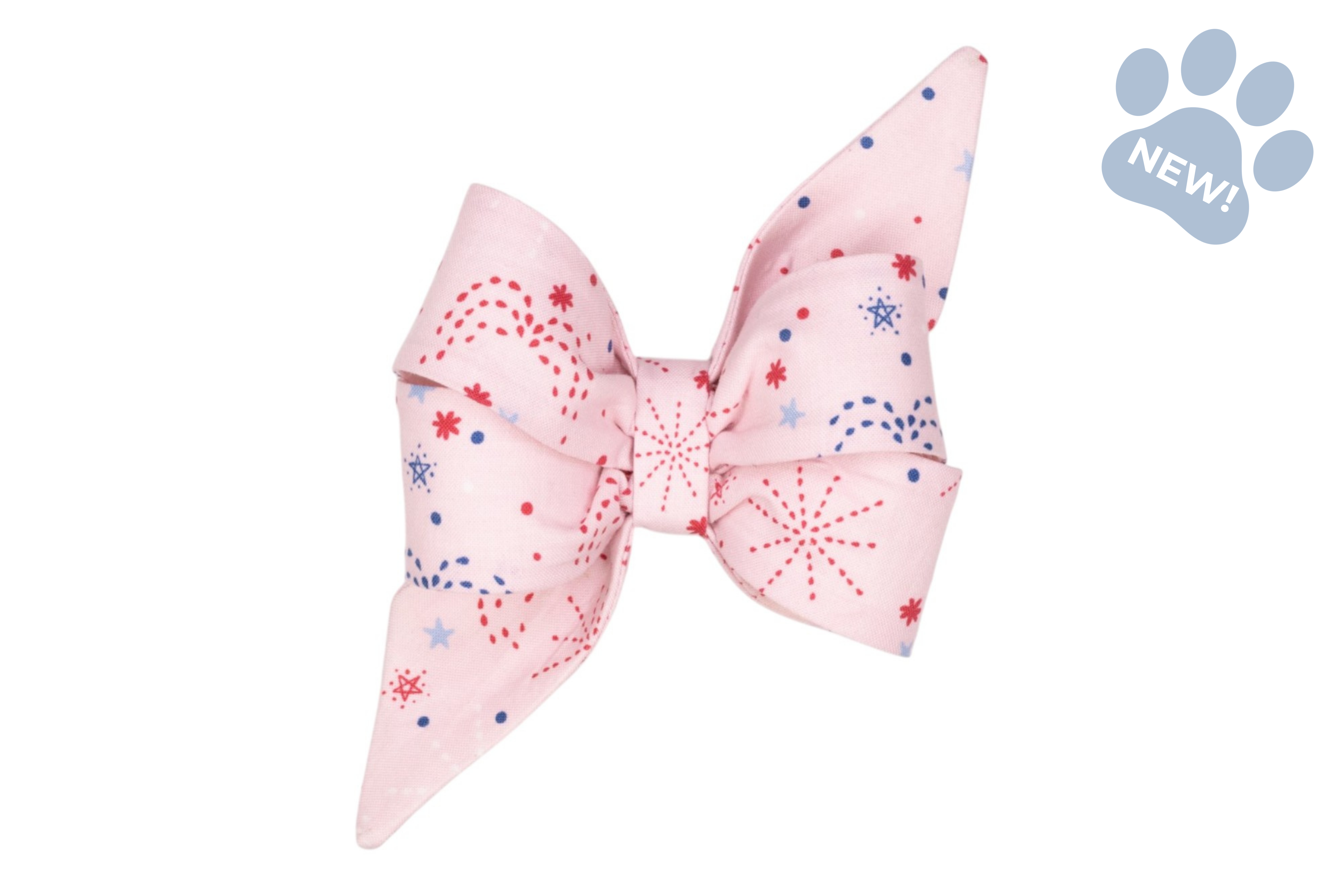 Pastel pink fabric bow featuring scattered red and blue starburst and dot prints, styled with long pointed ends.