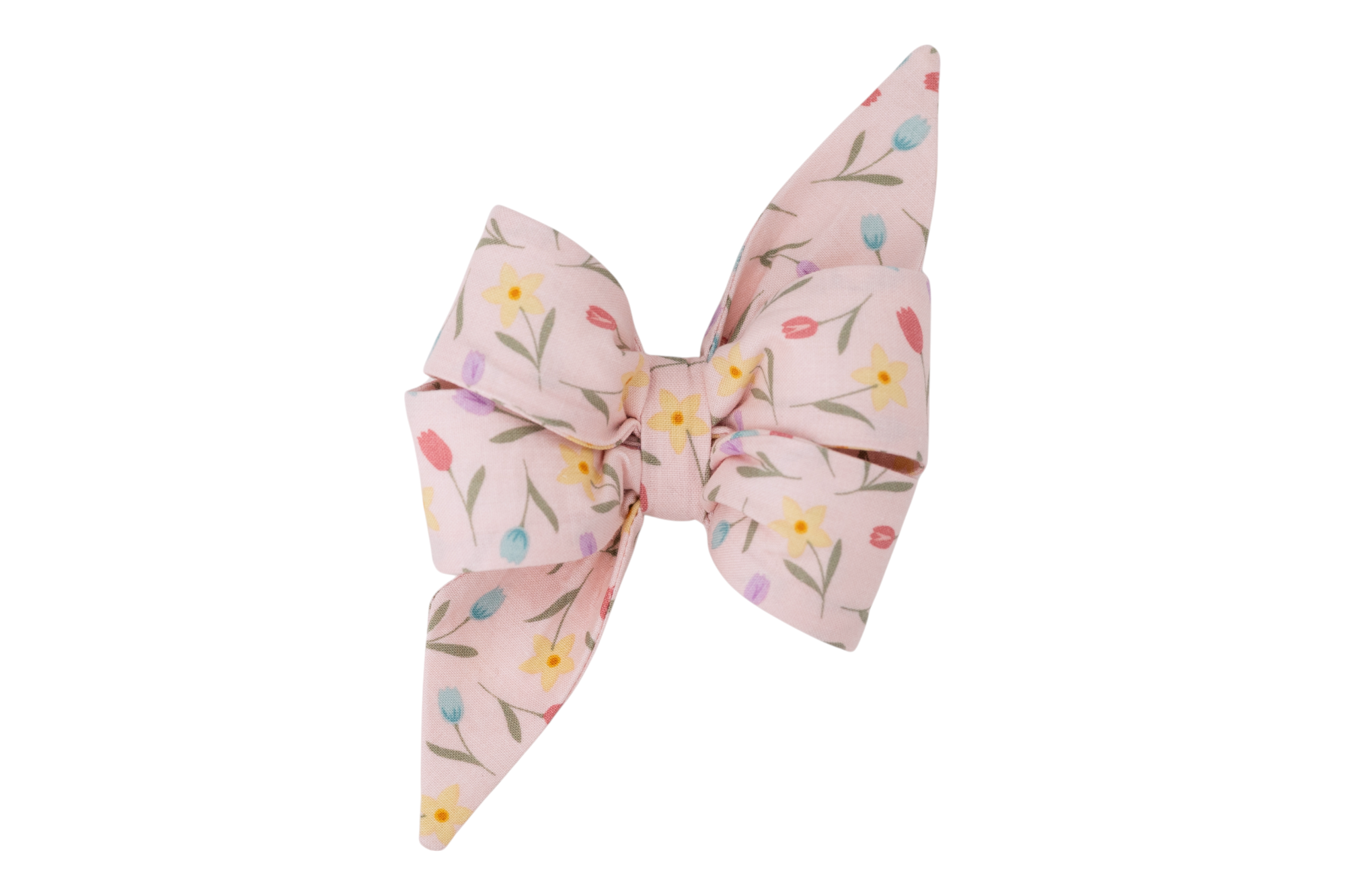 A pastel pink girl dog belle bow featuring a playful floral pattern with tulips and daffodils in shades of yellow, red, blue, and lavender, accented by green stems and leaves. Great for Spring!