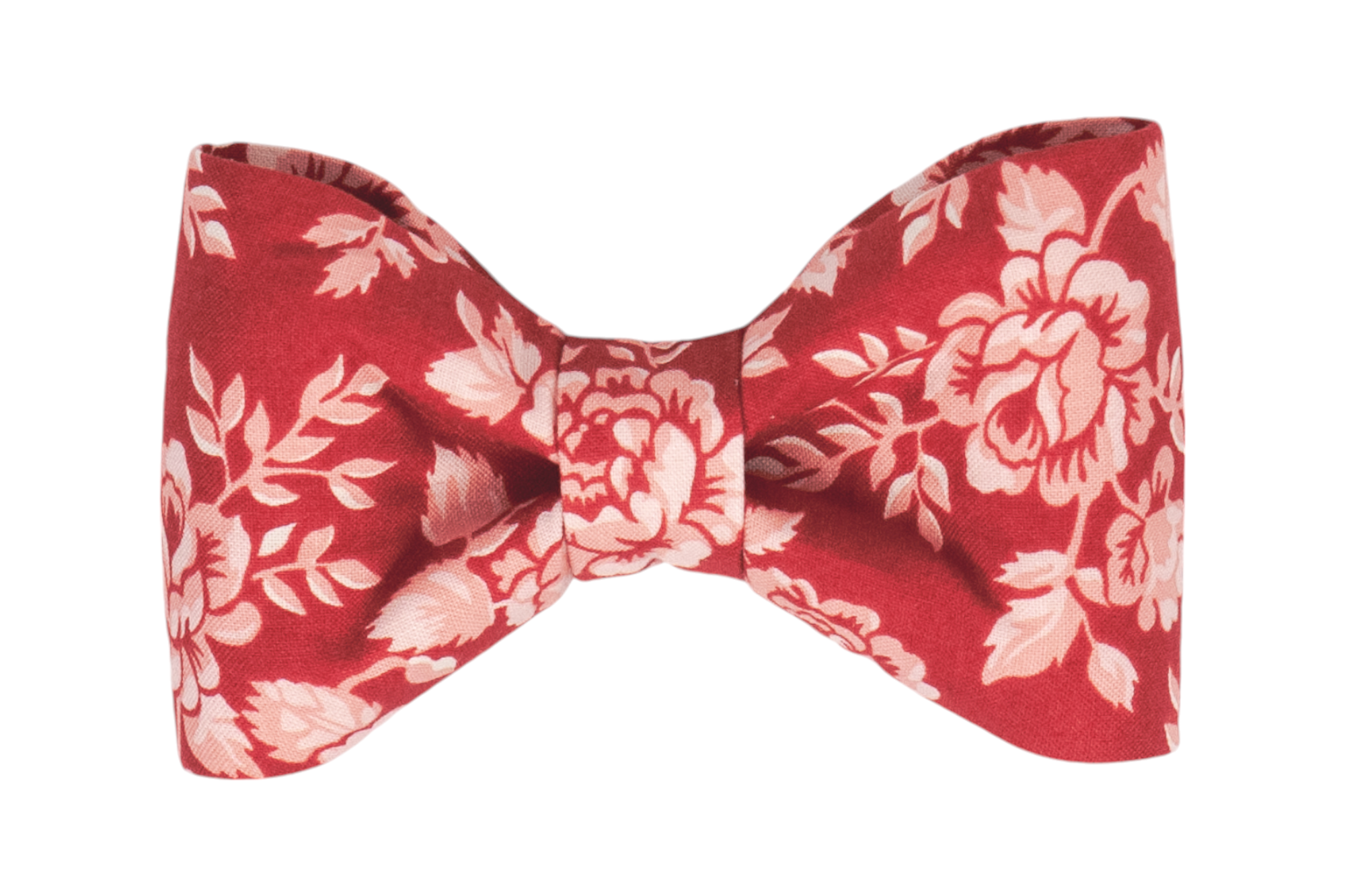 A handmade dog bow tie with an elegant red backdrop, beautifully decorated with vintage-inspired floral patterns in soft blush tones.