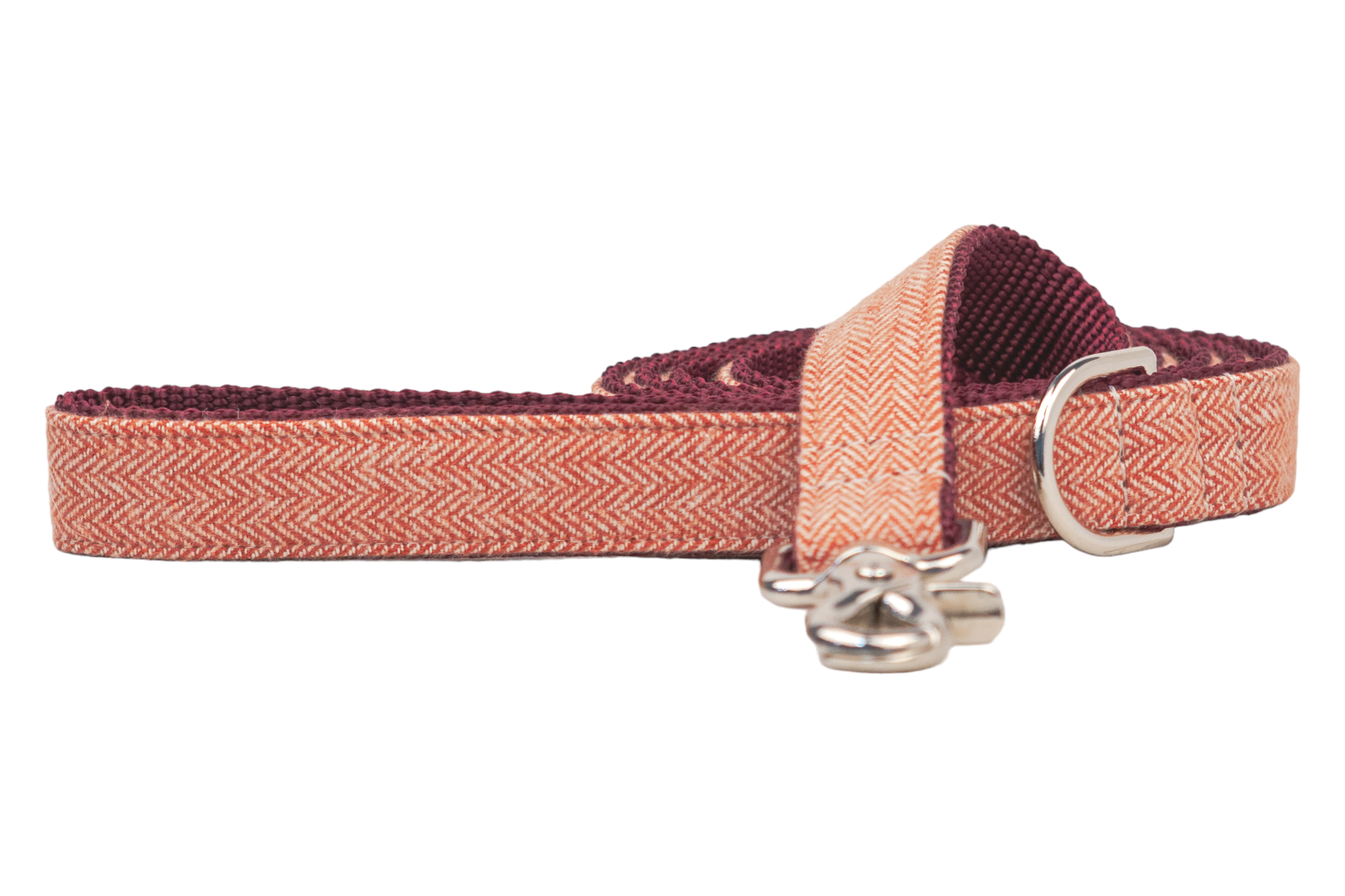 Durable dog leash featuring a tightly woven red herringbone fabric exterior, backed with sturdy burgundy ribbed webbing for reinforcement, and equipped with polished hardware including a swivel snap hook and a D-ring near the handle for accessories.