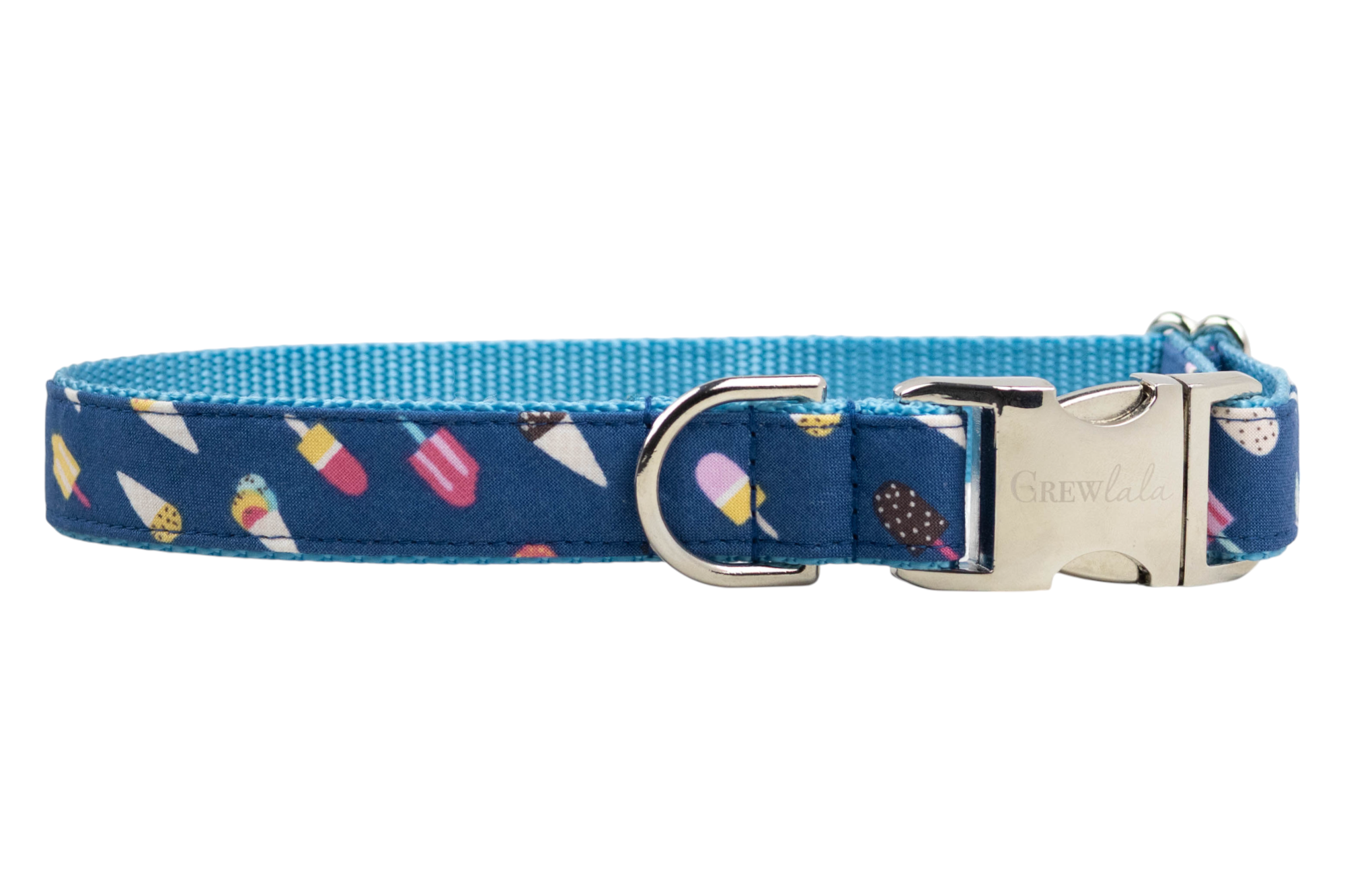 Colorful dog collar with a summery dessert print on dark blue fabric, showing various ice cream cones and popsicles. The collar includes a blue woven backing, a gold metal D-ring for leash attachment, and a polished silver side-release buckle with “Crewlala” branding.