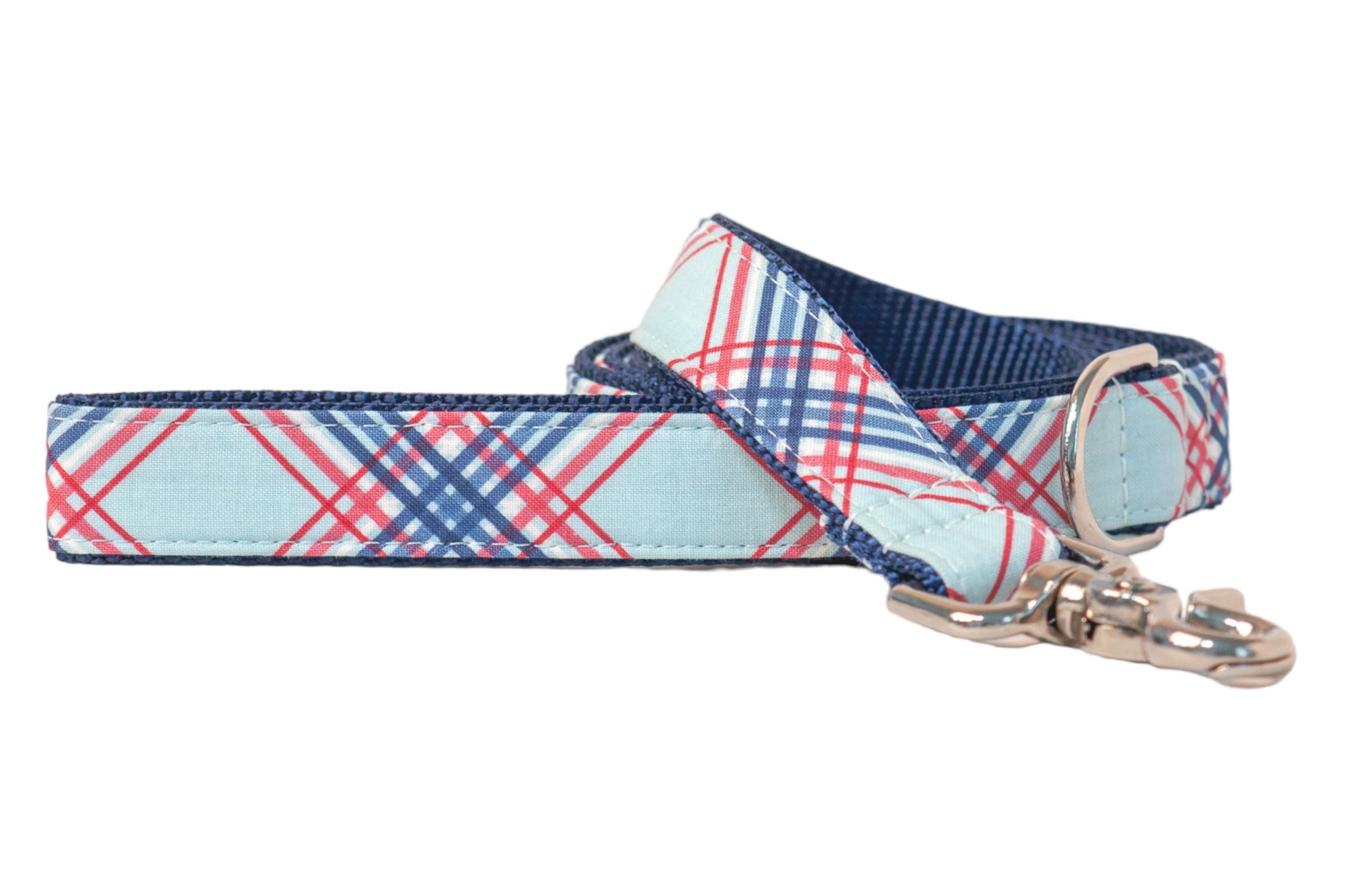 A stylish dog leash with a light blue fabric exterior featuring a red, navy, and white plaid pattern. The leash has a dark blue webbing and reinforced stitching. A shiny silver metal clasp and a D-ring are visible at the end for attaching to a collar or accessories, all displayed on a white background.