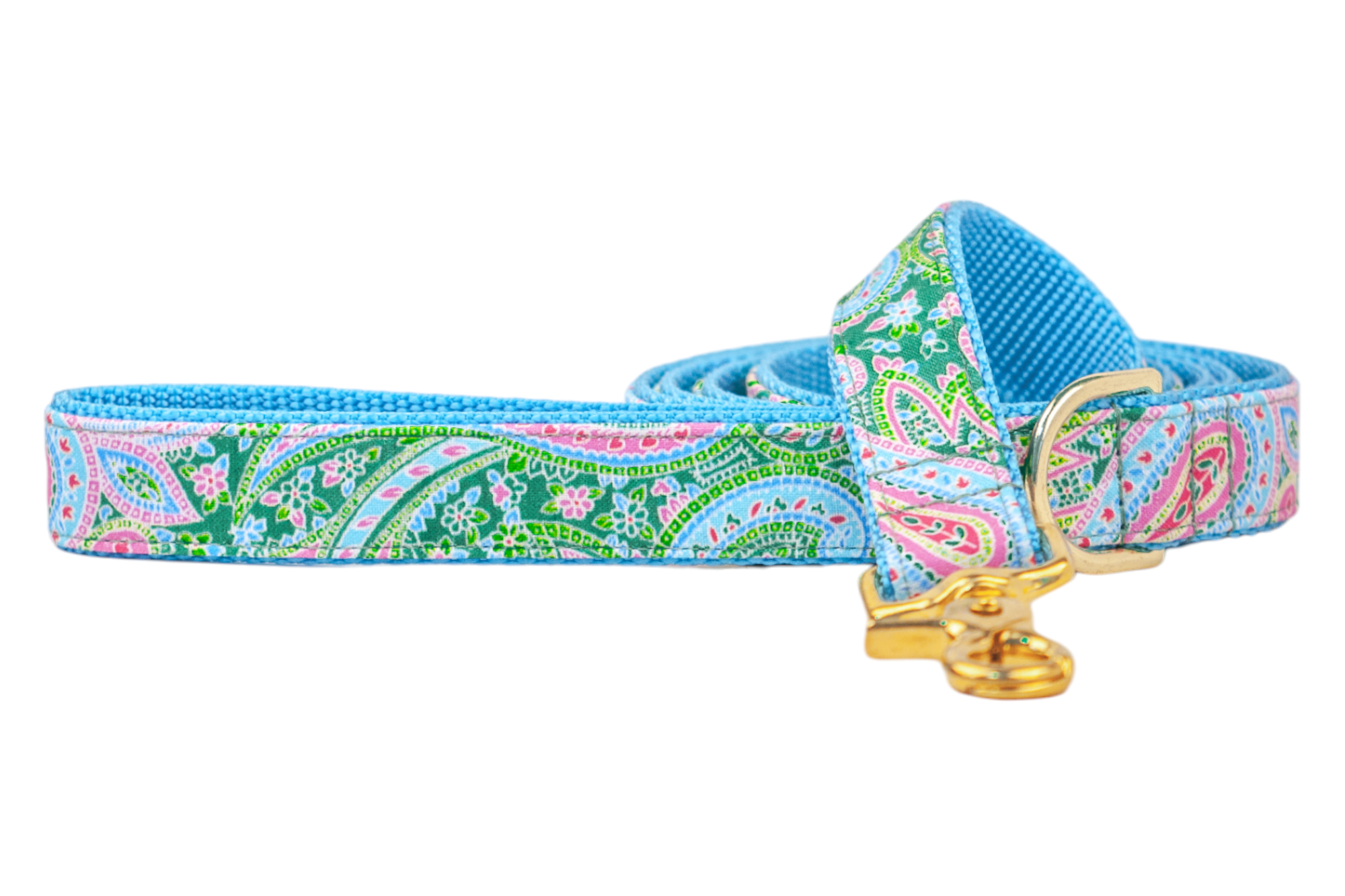 A dog leash featuring a colorful paisley print in pink, green, and blue with floral accents. The leash is shown coiled, with a bright blue inner webbing and finished with polished gold hardware, including a swivel clasp and D-ring.